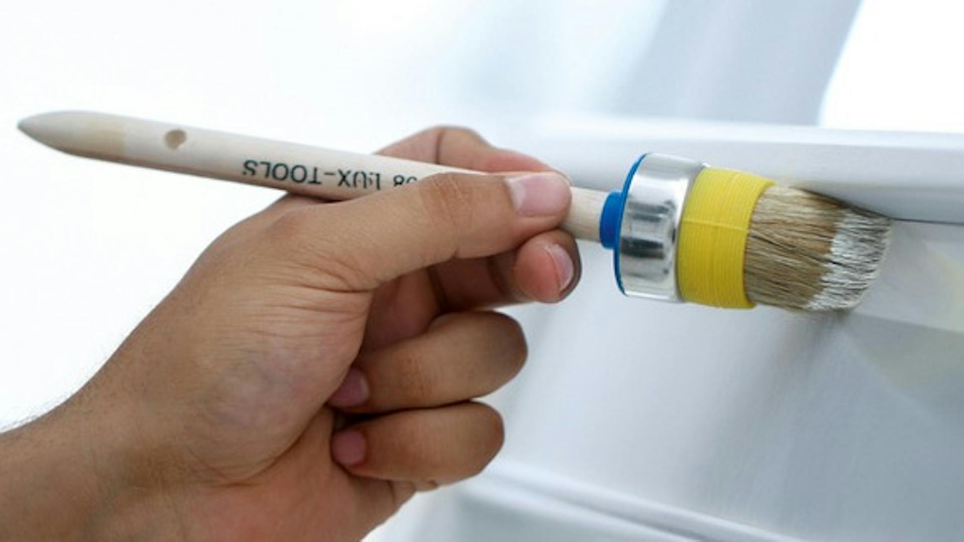 La porta è verniciata di bianco con un pennello tondo.