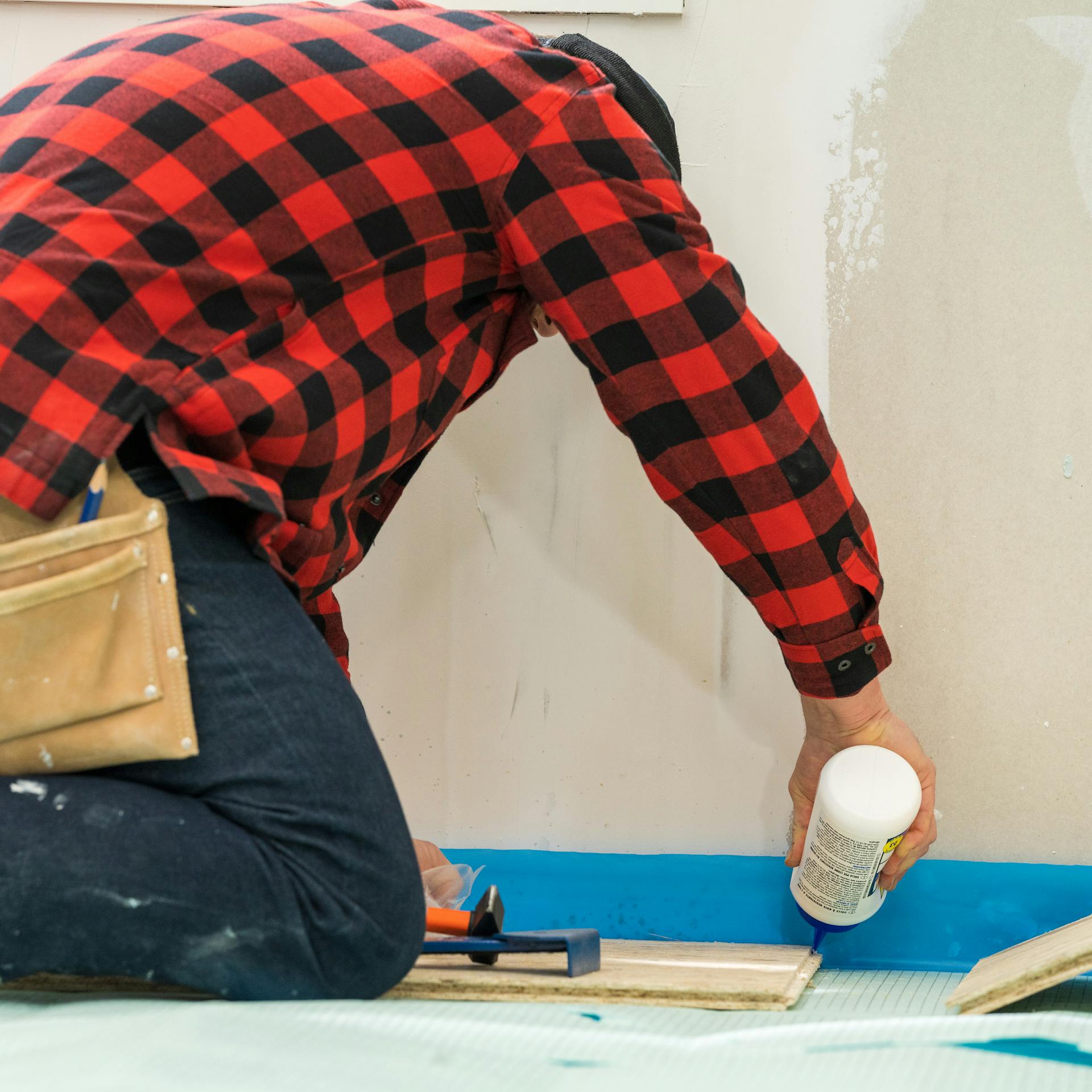 Heimwerker verbindet die erste Reihe der OSB-Platten mit Fugenleim.