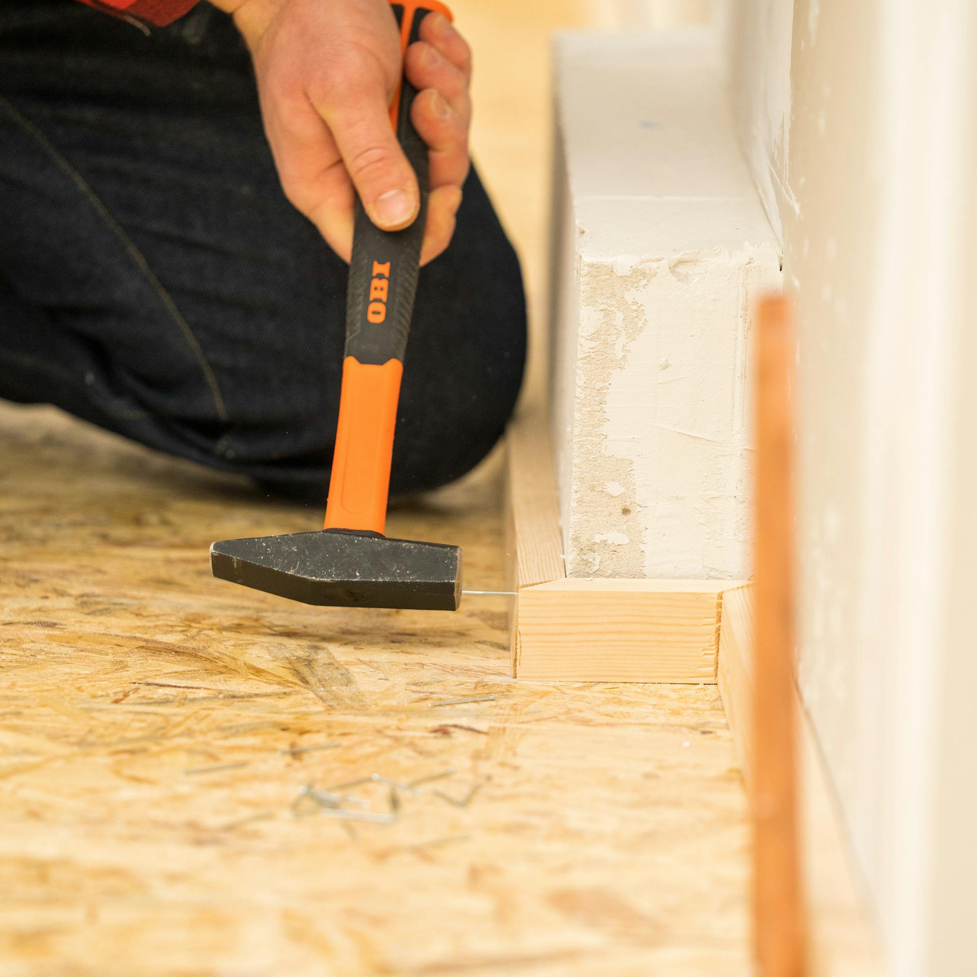 Heimwerker bringt die Fußleisten an.