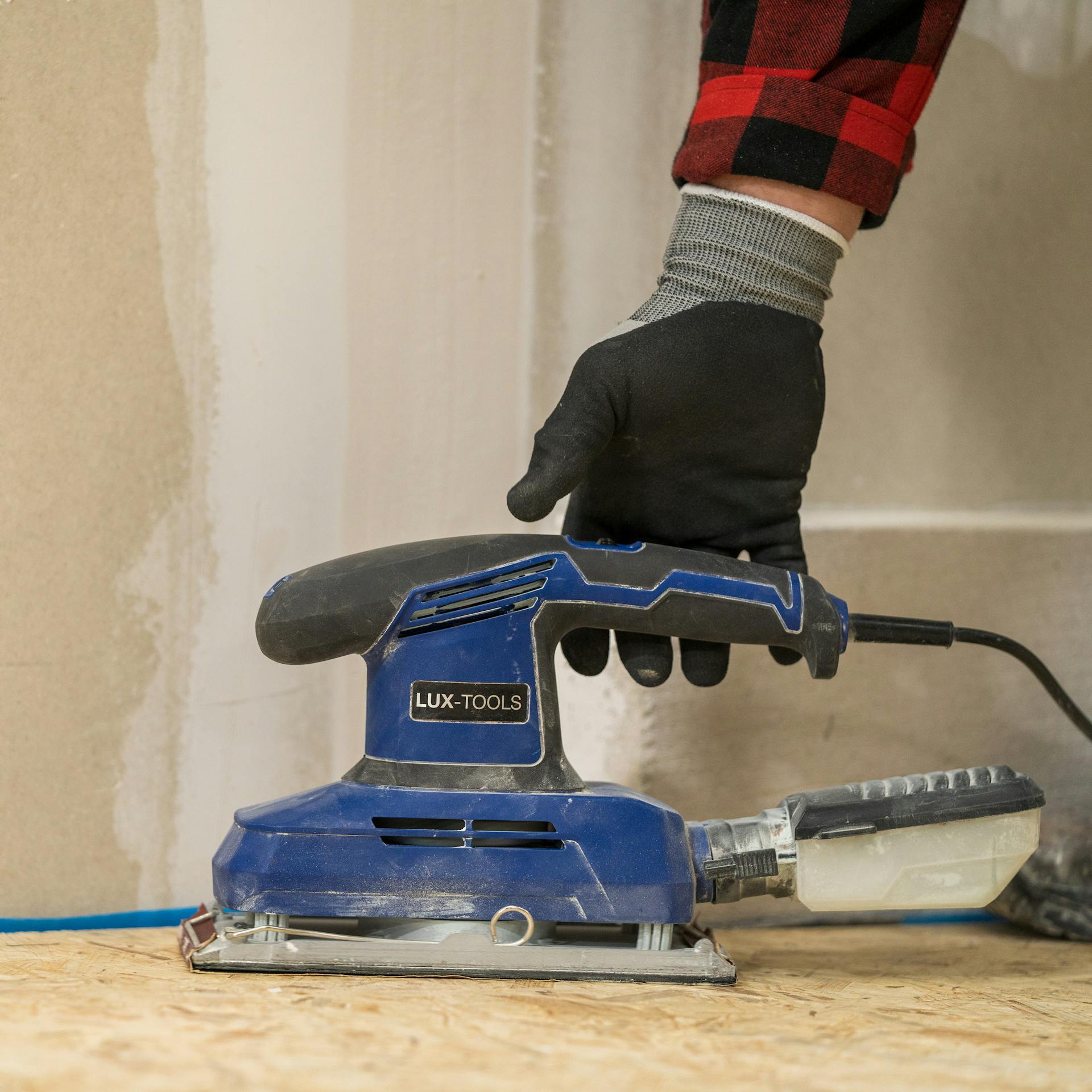 Heimwerker schleift OSB-Platten ab.