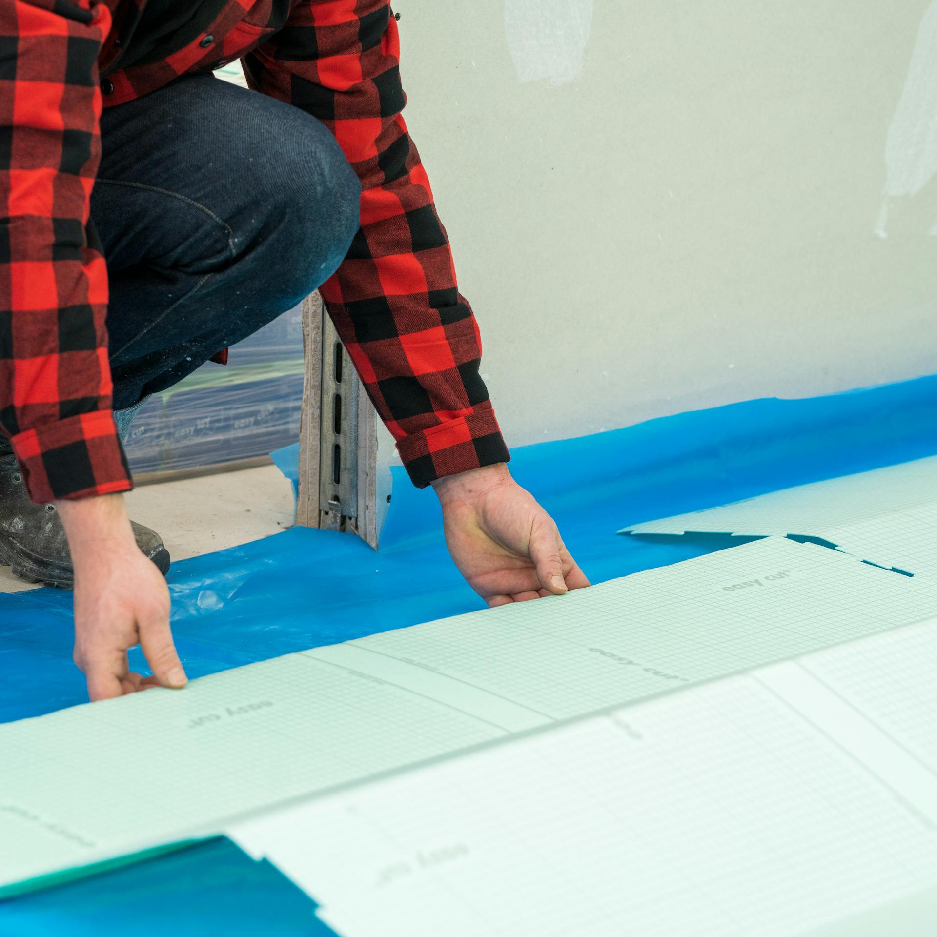 Heimwerker verlegt Trittschalldämmung auf die Dampfsperre.