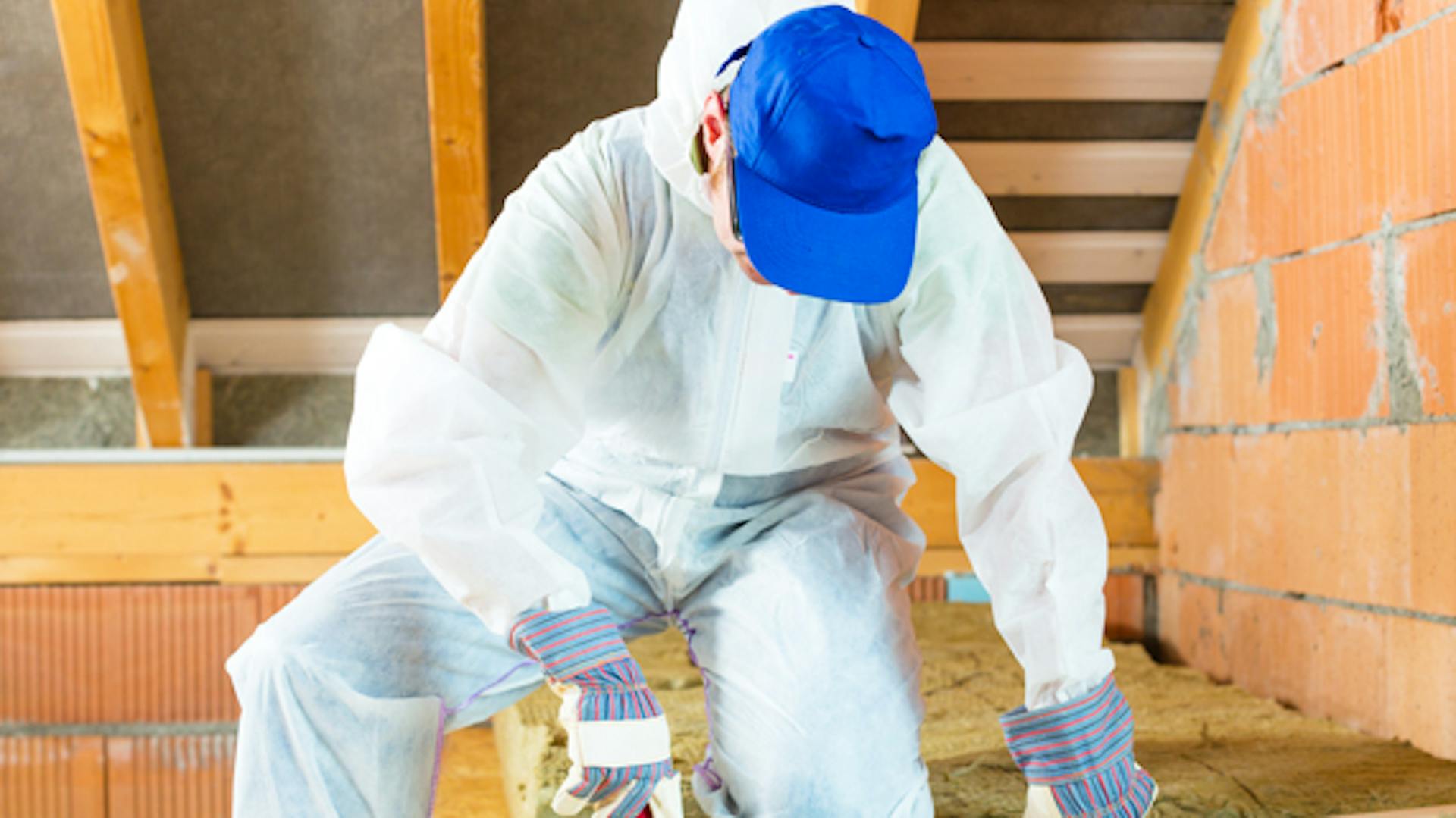 Ezermester szigetelőanyagot vág a tetőszigeteléshez.