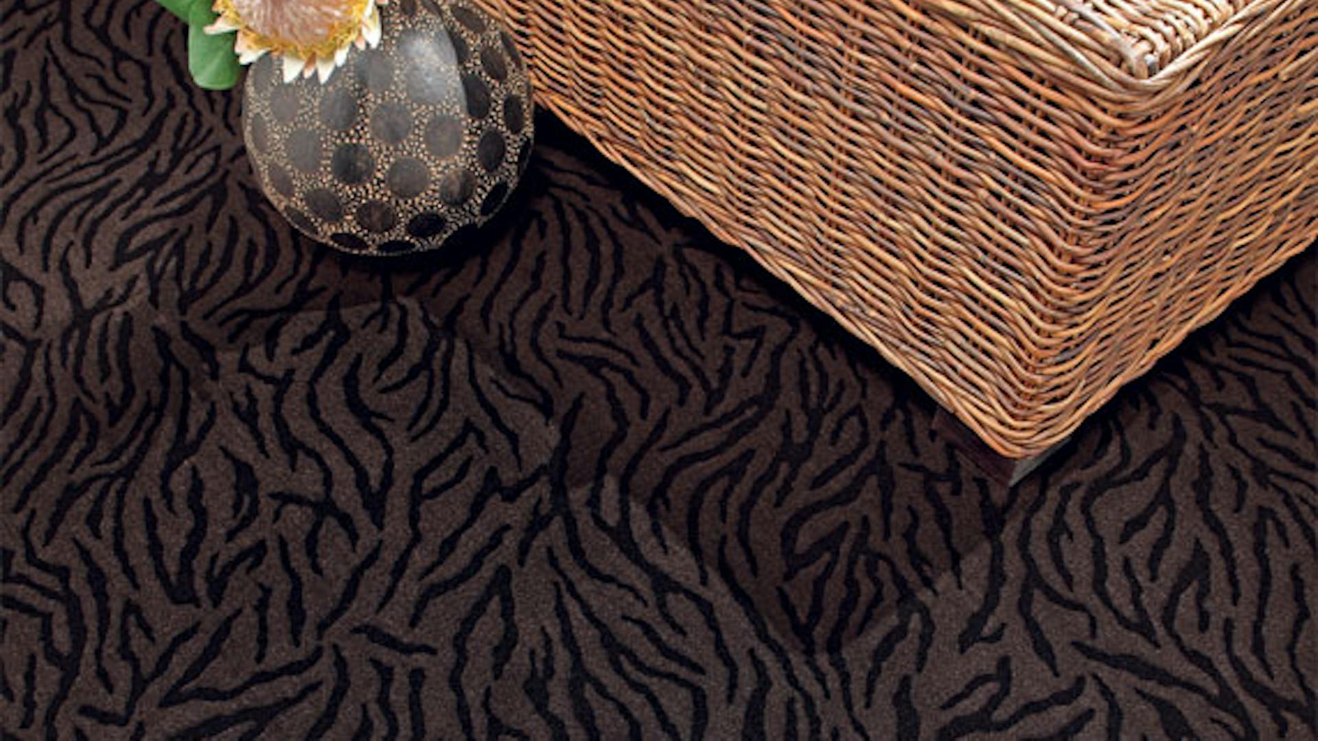 Gemusterter Schlingenteppichboden mit einem Korb und einer Blume in einer Vase.