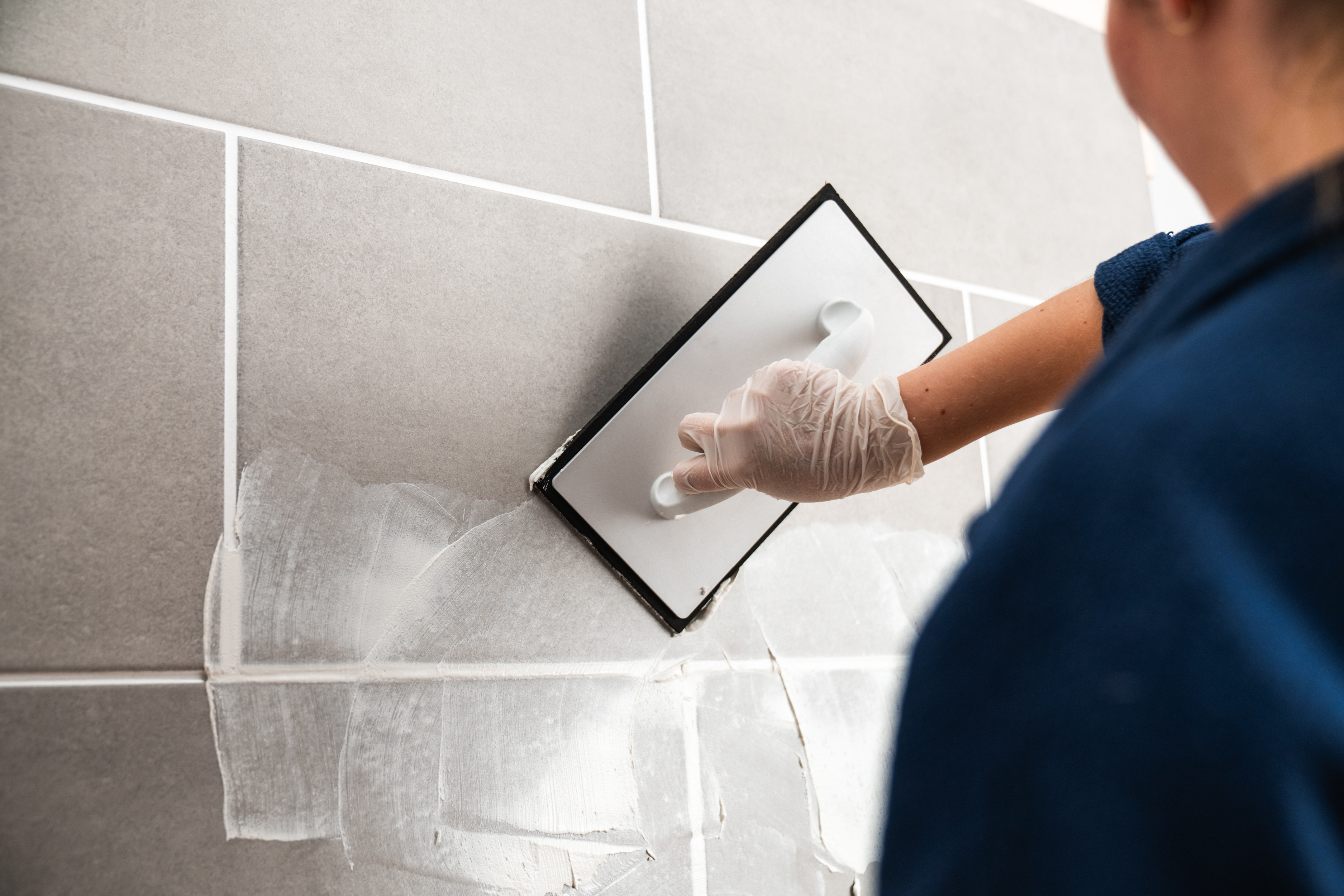 Osoba stierkuje obkladačky