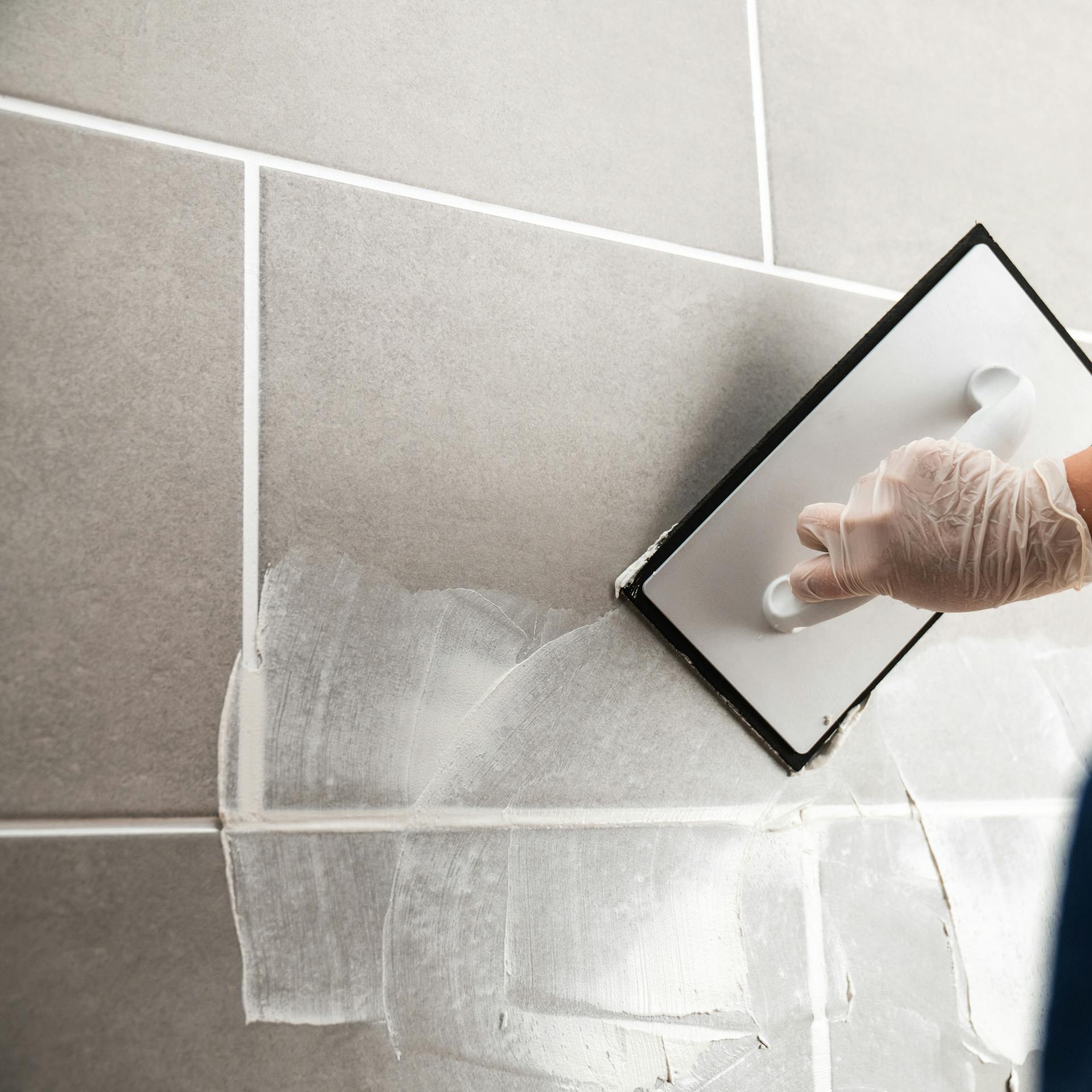 Osoba stierkuje obkladačky