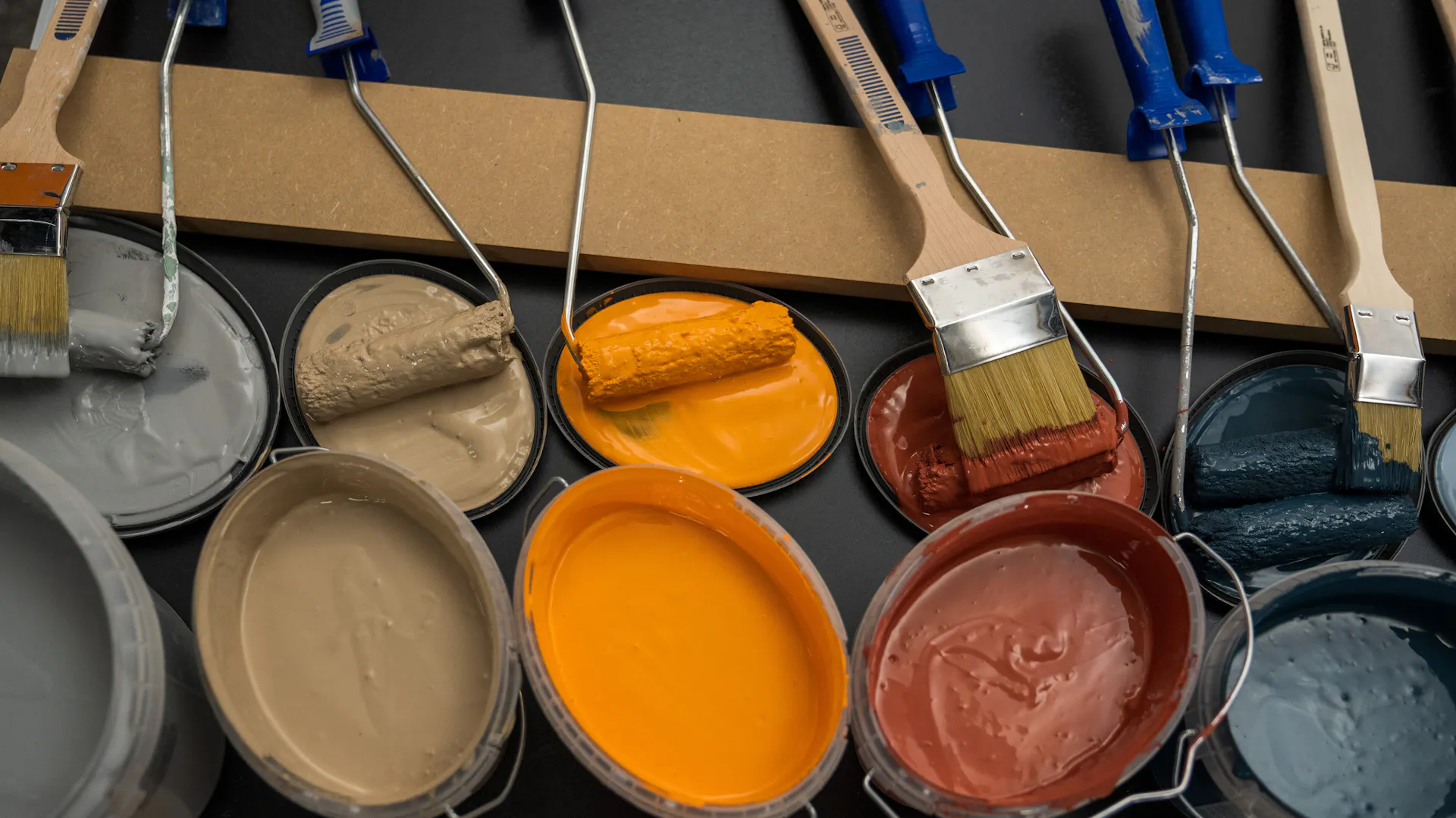 Několik kbelíků barevné barvy na stěny.