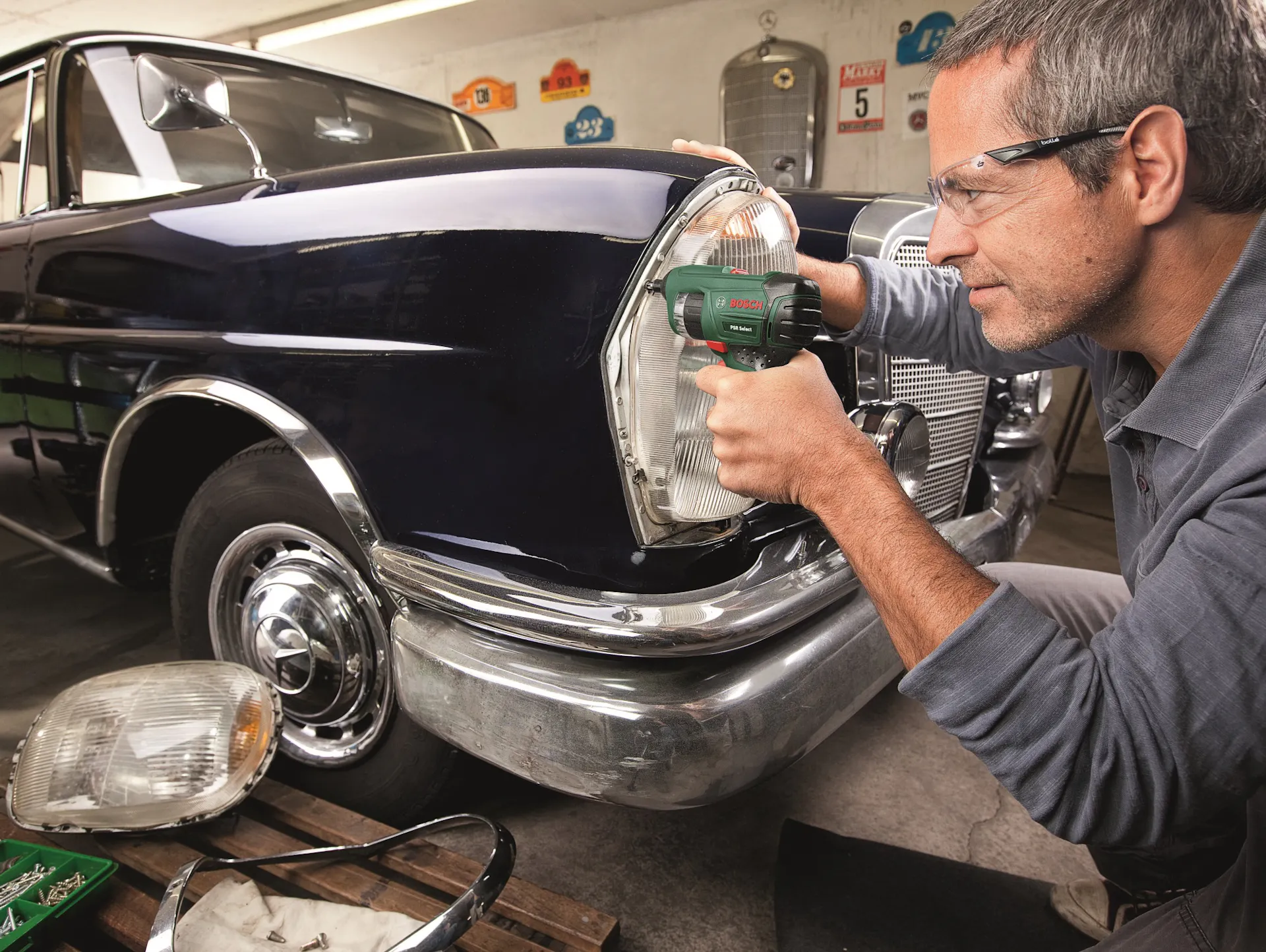Una persona ripara i fari dell’auto nella propria officina.