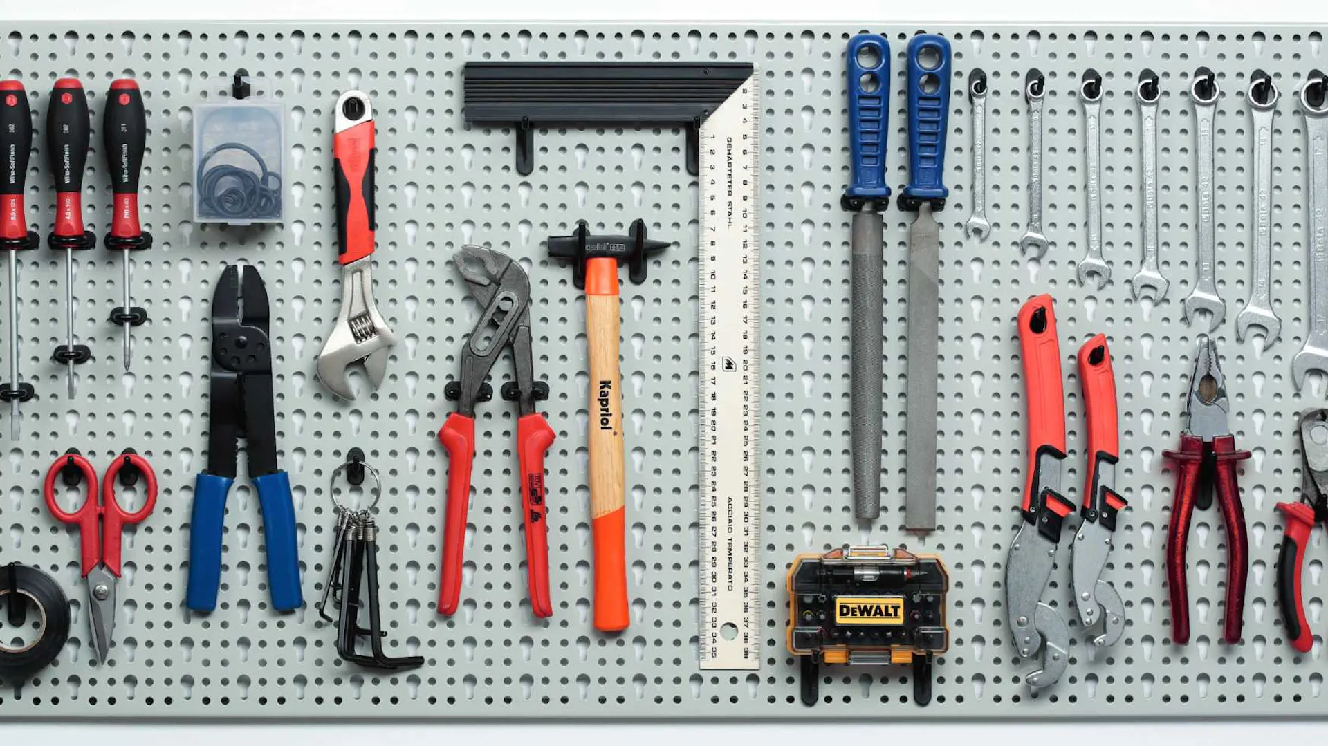 Gli attrezzi sono appesi a una parete perforata in officina.