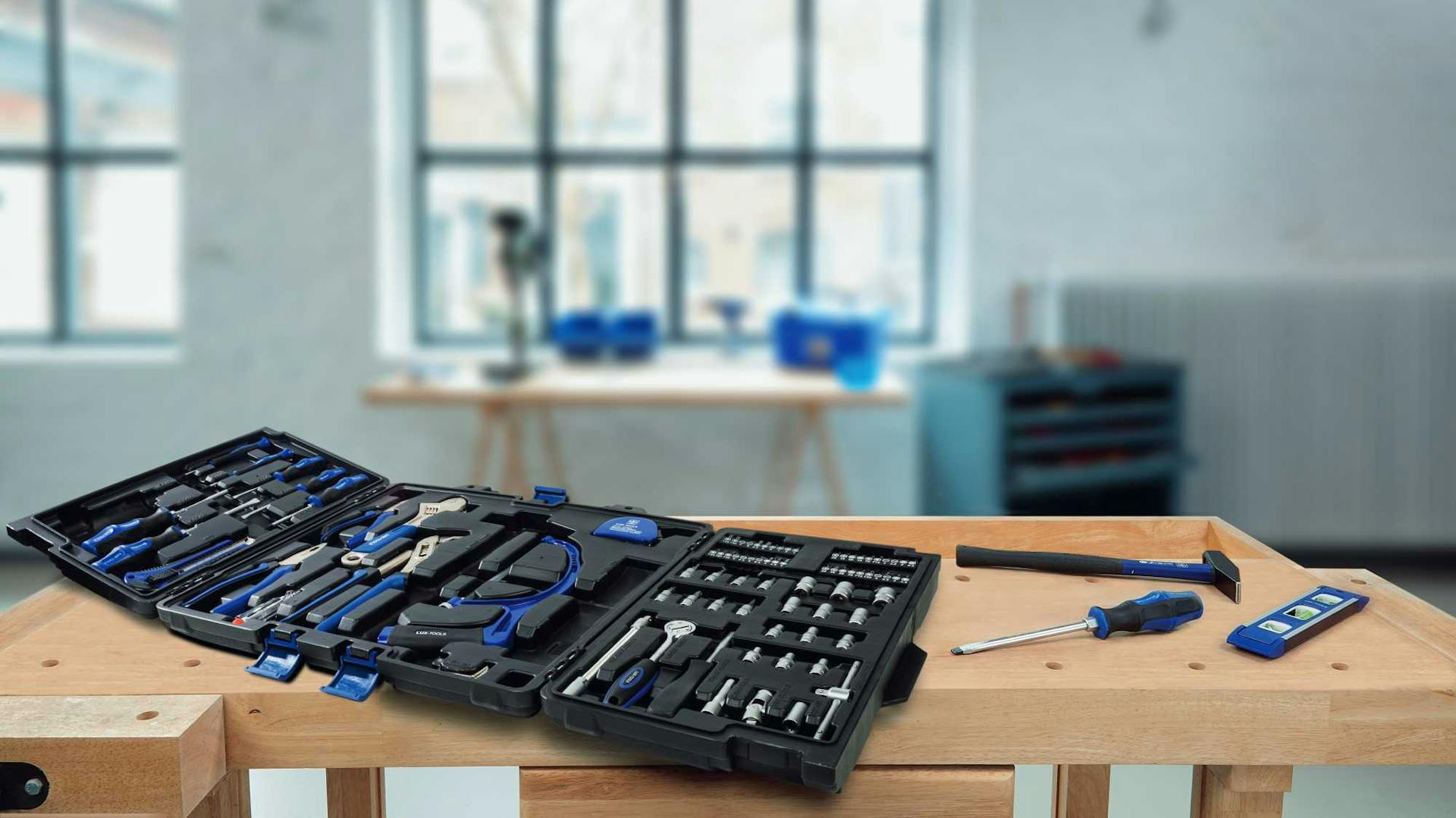 Werkzeugkoffer auf Tisch in Werkstatt mit großem Fenster