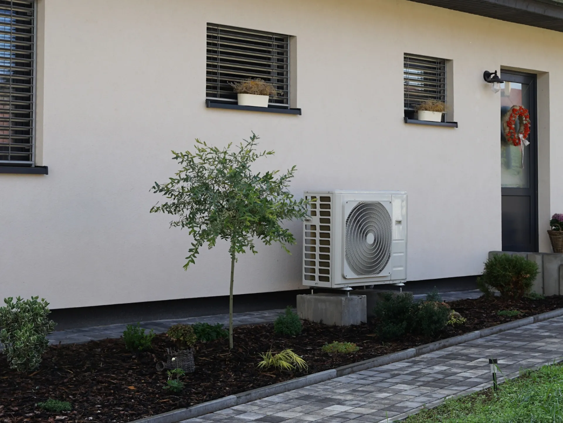 Eine Wärmepumpe steht an einem Haus.