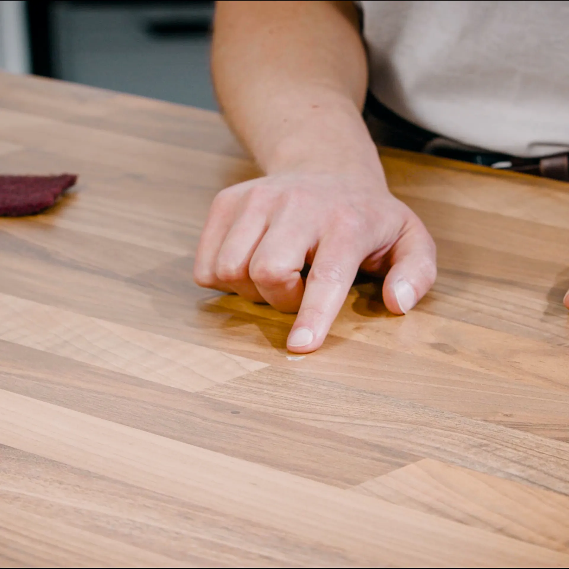 Handwerker fühlt mit Fingern die ausgebesserte Stelle nach.