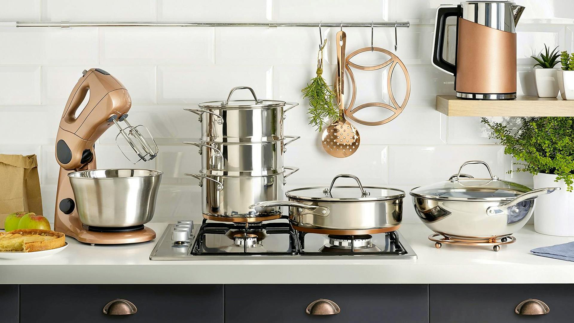 Töpfe in unterschiedlichen Größen auf einem Gasherd. Daneben eine Küchenmaschine und ein Wasserkocher.