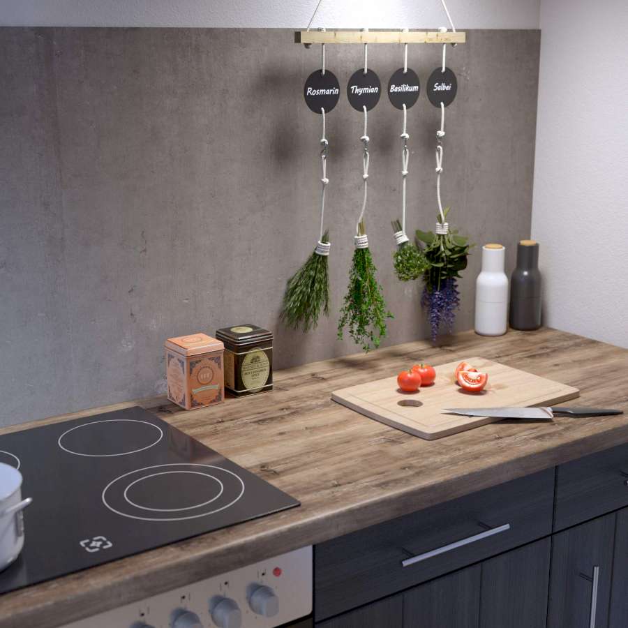 Eine Küchenzeile mit schwarzer Front, die eine Betonoptik-Rückwand hat, vor der Kräuter hängen