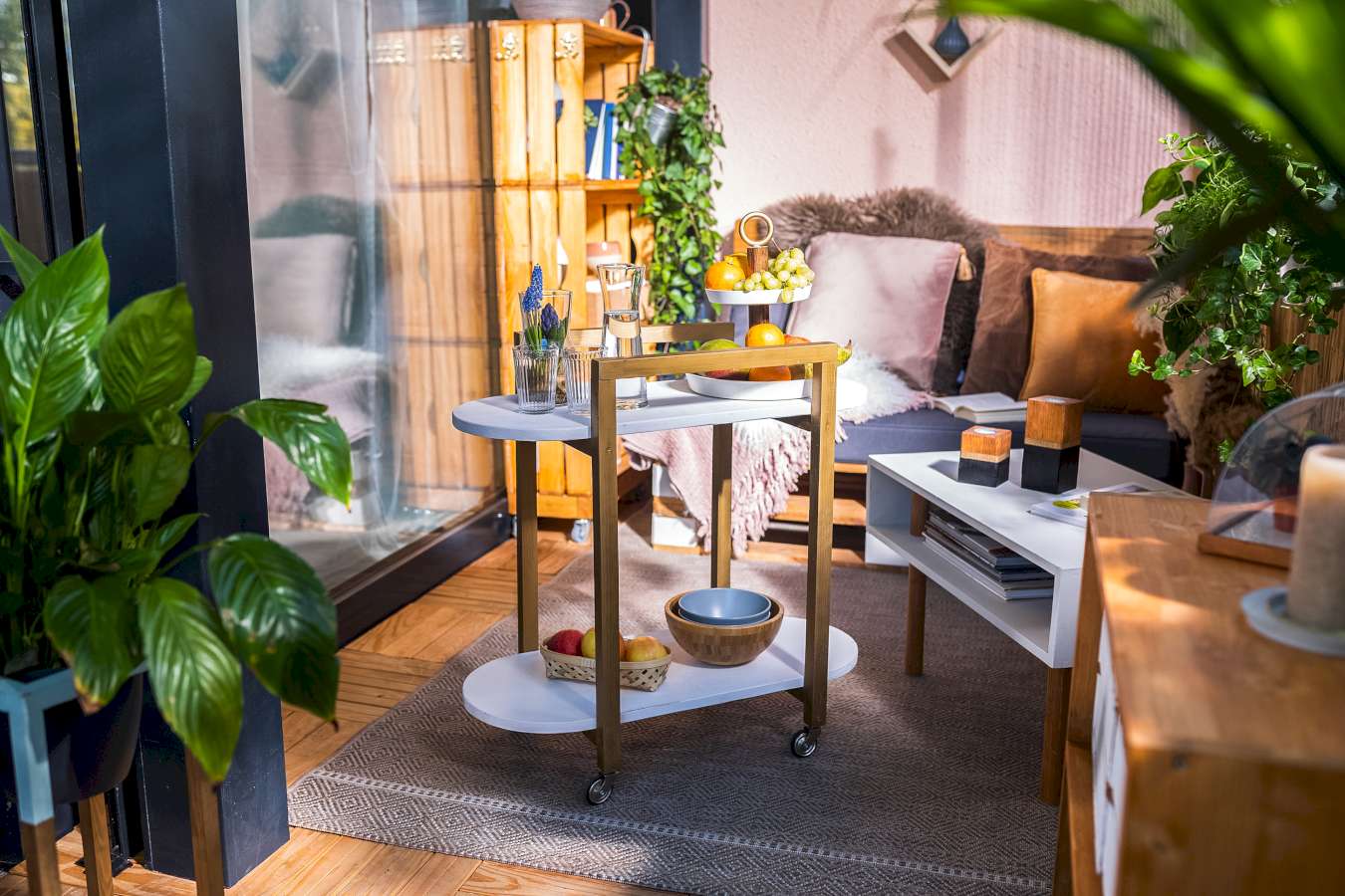 Ein klassischer Servierwagen steht auf einem gemütlich eingerichteten Balkon