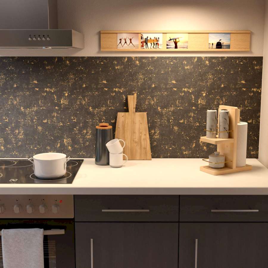 Dunkle Küchenunterschränke mit einer weißen Arbeitsplatte über der eine schwarze Vliestapete mit goldenen Akzenten als Küchenrückwand dient