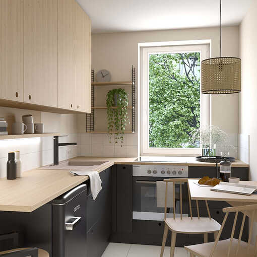 Küche mit schwarzen Unterschränken, eichenfarbener Arbeitsplatte und Hochschränken, sowie einem einklappbaren Küchentisch.