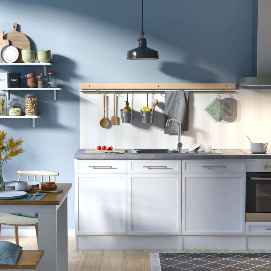 Eine blau gestaltete Küche mit hellen Unterschränken und einer gestreiften Vliestapete als Küchenrückwand