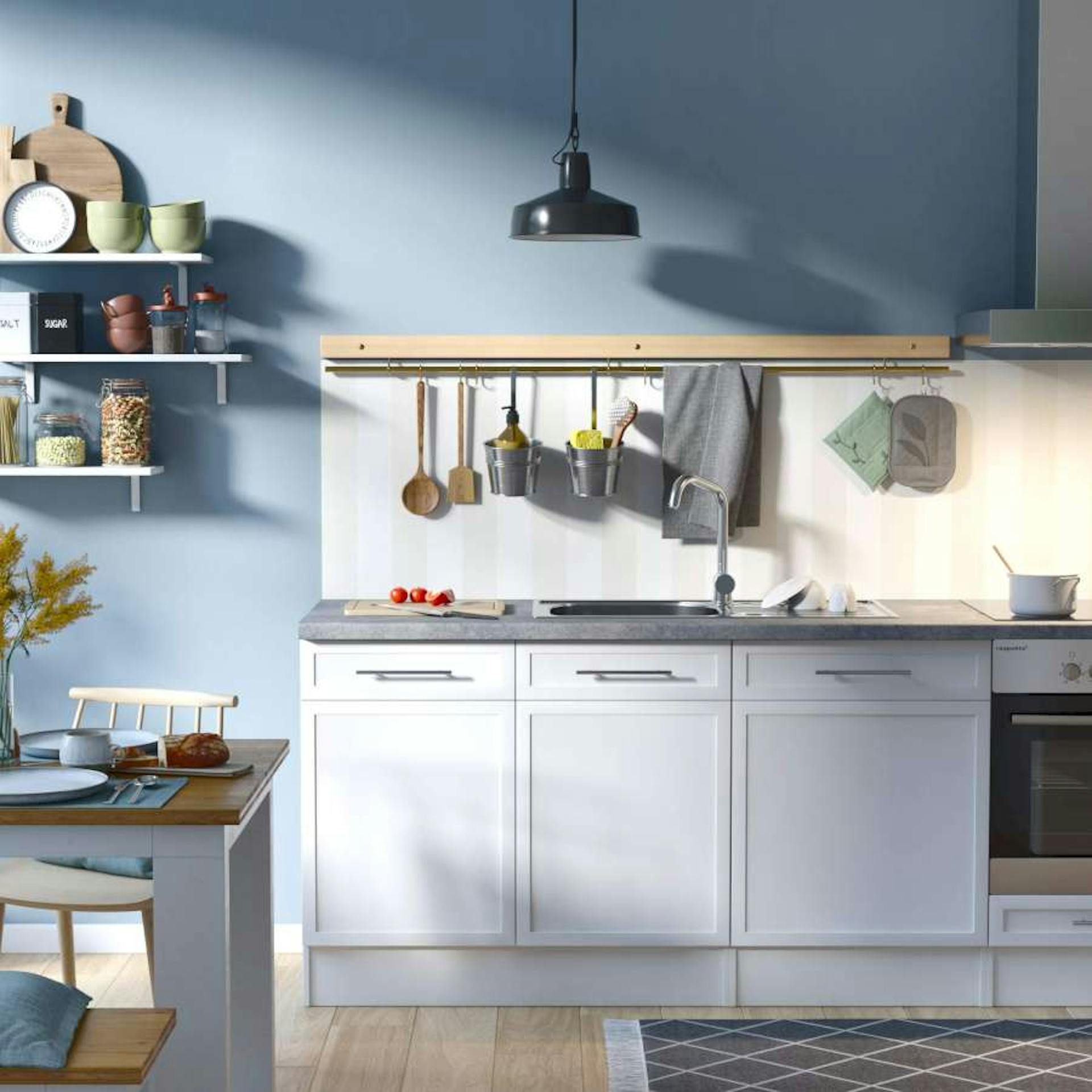 Eine blau gestaltete Küche mit hellen Unterschränken und einer gestreiften Vliestapete als Küchenrückwand