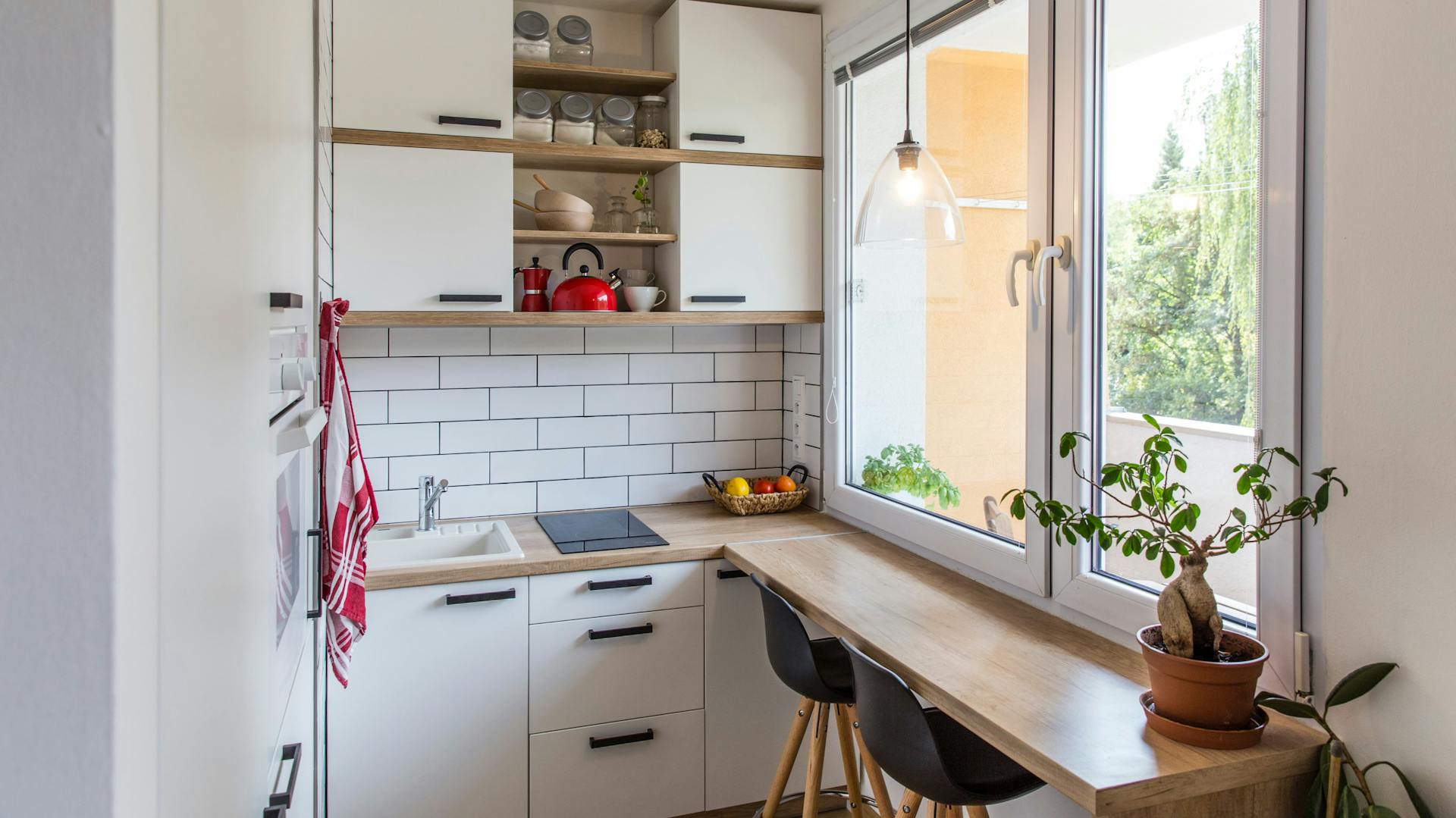 Schmale, weiß-braune Küche mit kleiner Sitzecke.