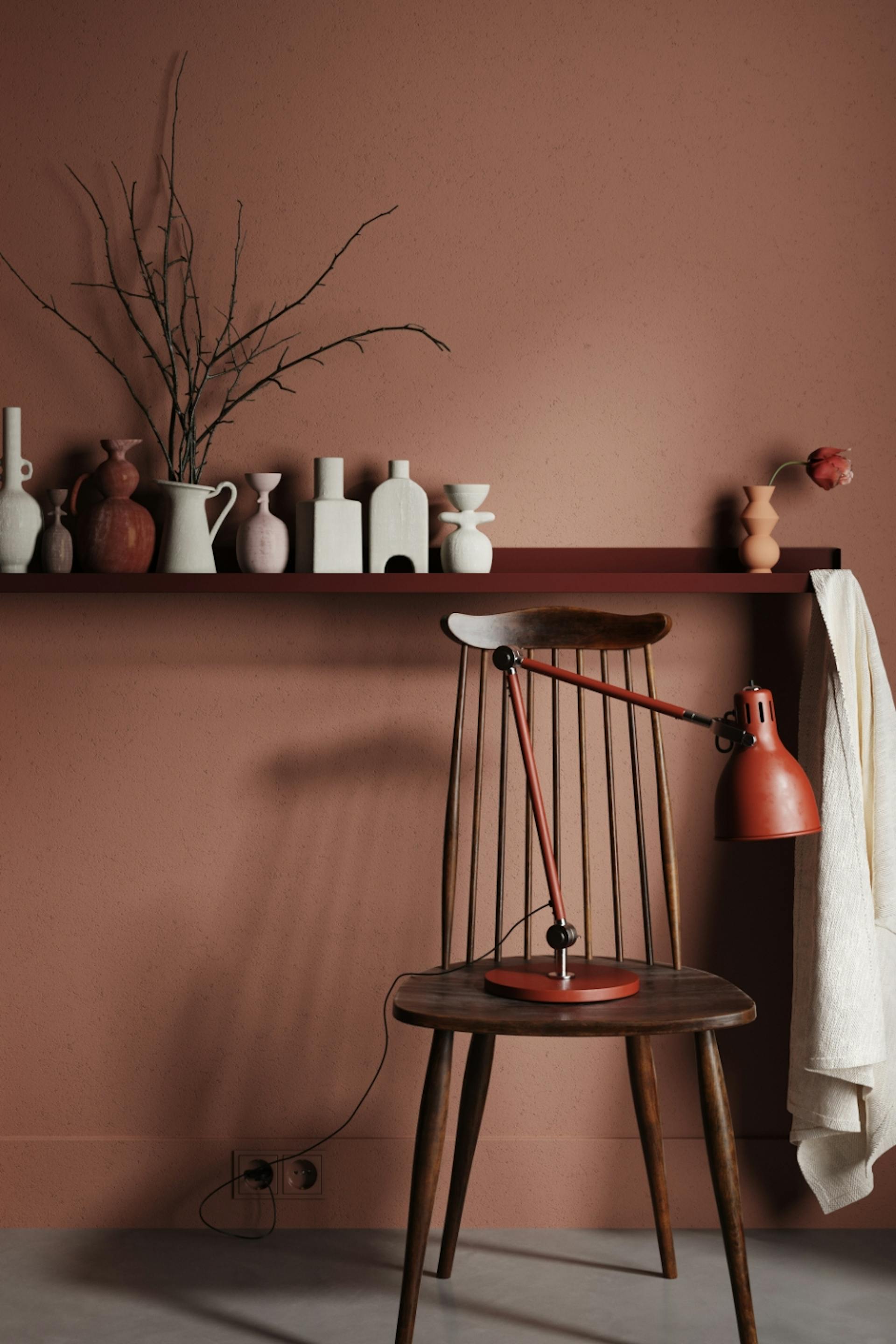 Barna fal, szék, polc fehér vázákkal.