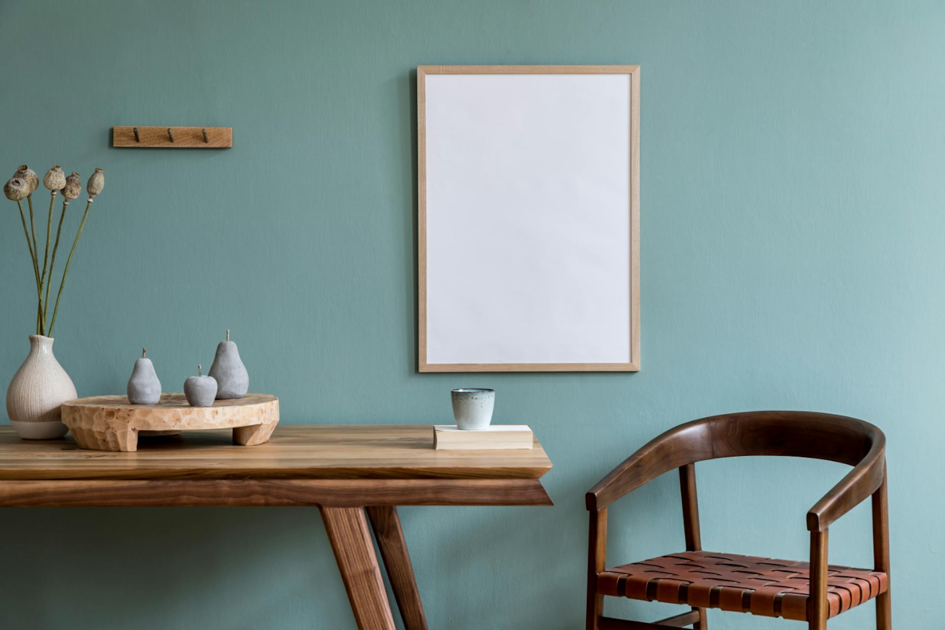 Faasztal székkel kékes-szürke fal előtt, fehér képpel