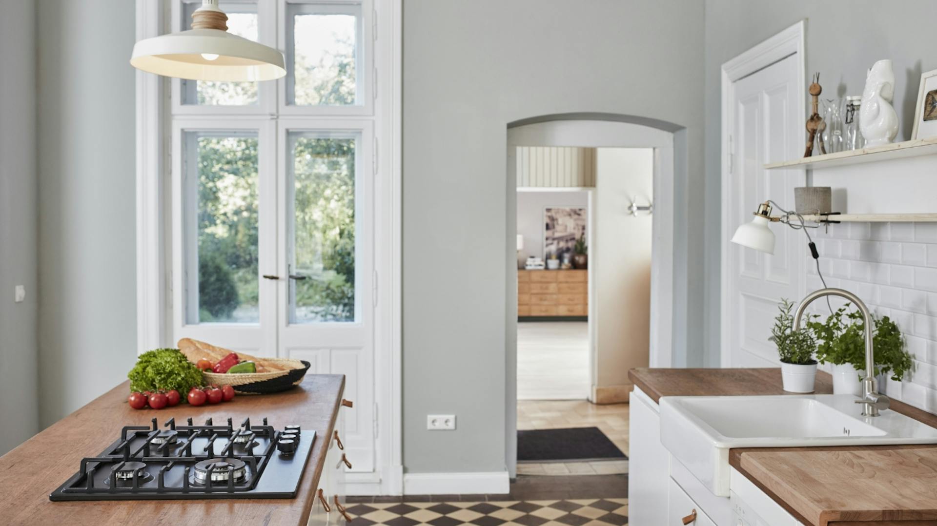 Cucina con frontali bianchi e parete grigia