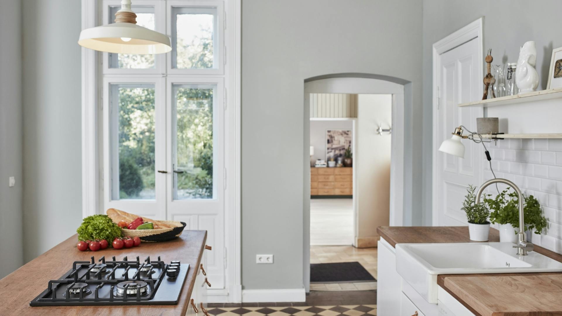 Vidéki stílusú konyha fehér ajtófrontokkal, átjáróval és teraszajtóval