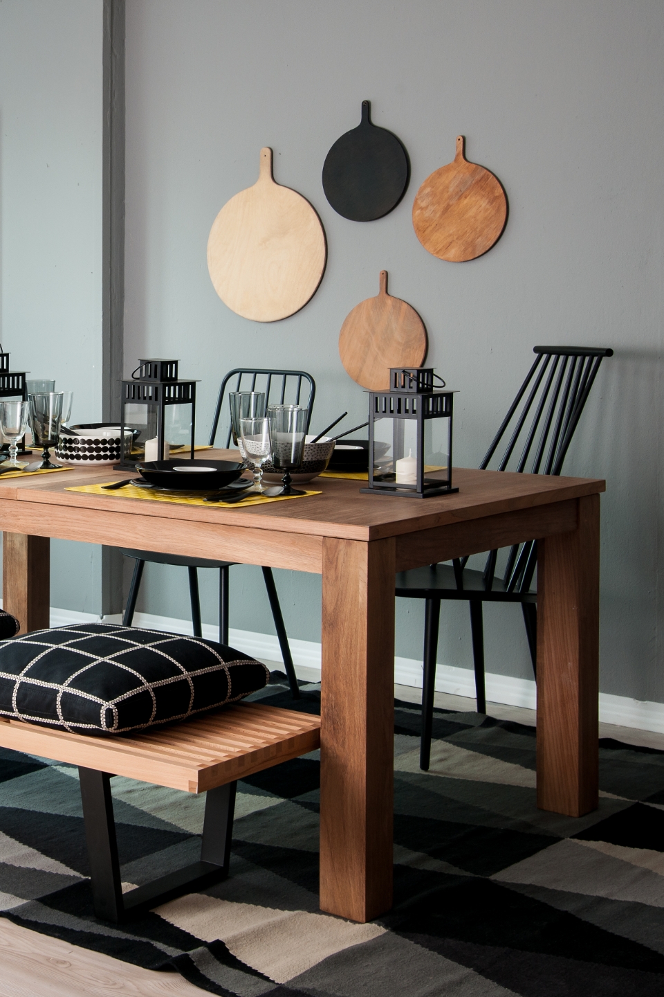 Faasztal fekete székekkel, szürke fal fekete-fehér fali dekorációval