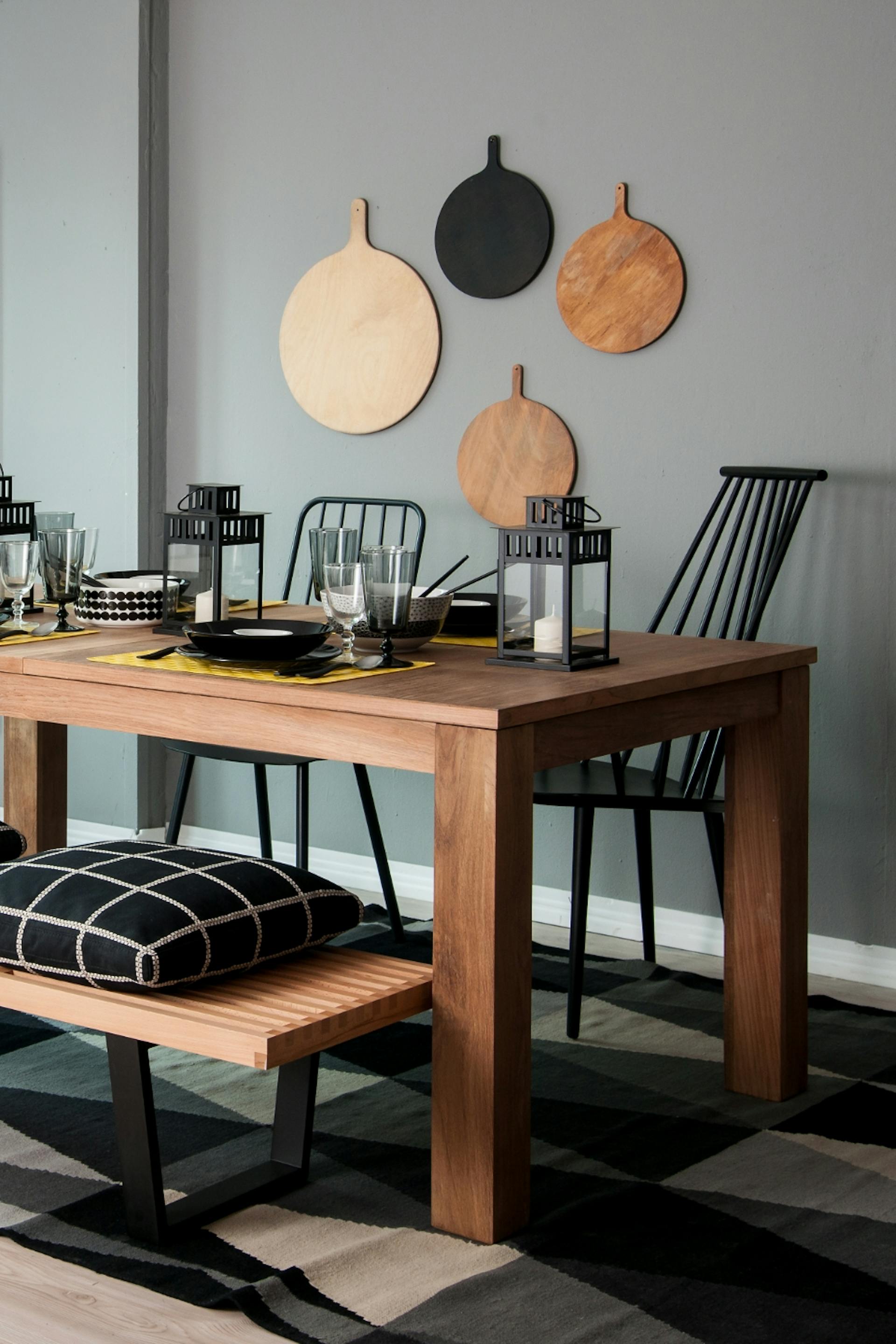 Faasztal fekete székekkel, szürke fal fekete-fehér fali dekorációval