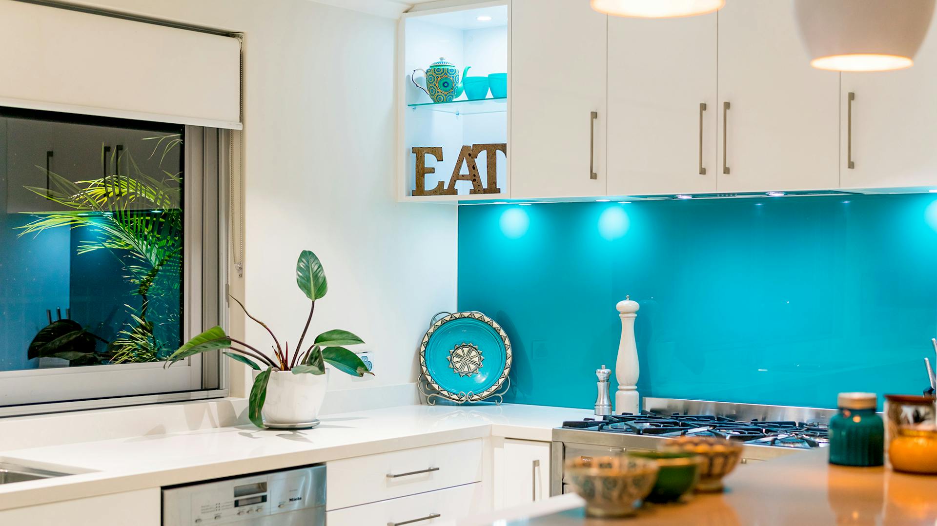 Fehér modern konyha kék hangsúlyú fallal