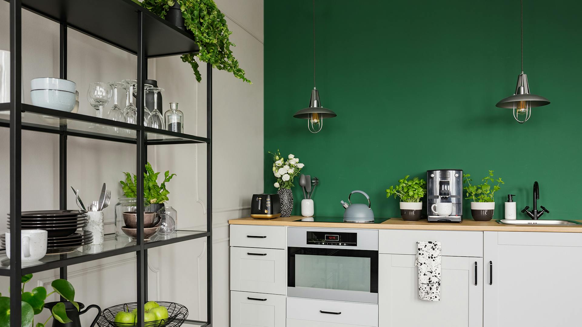 Weiße Küchenfront mit schwarzen Elementen und einer dunkelgrünen Akzentwand