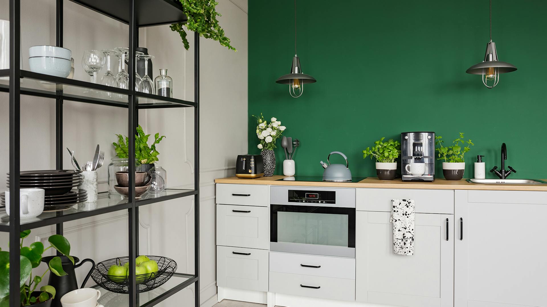 Eine helle Küche mit dunkelgrüner Akzentwand