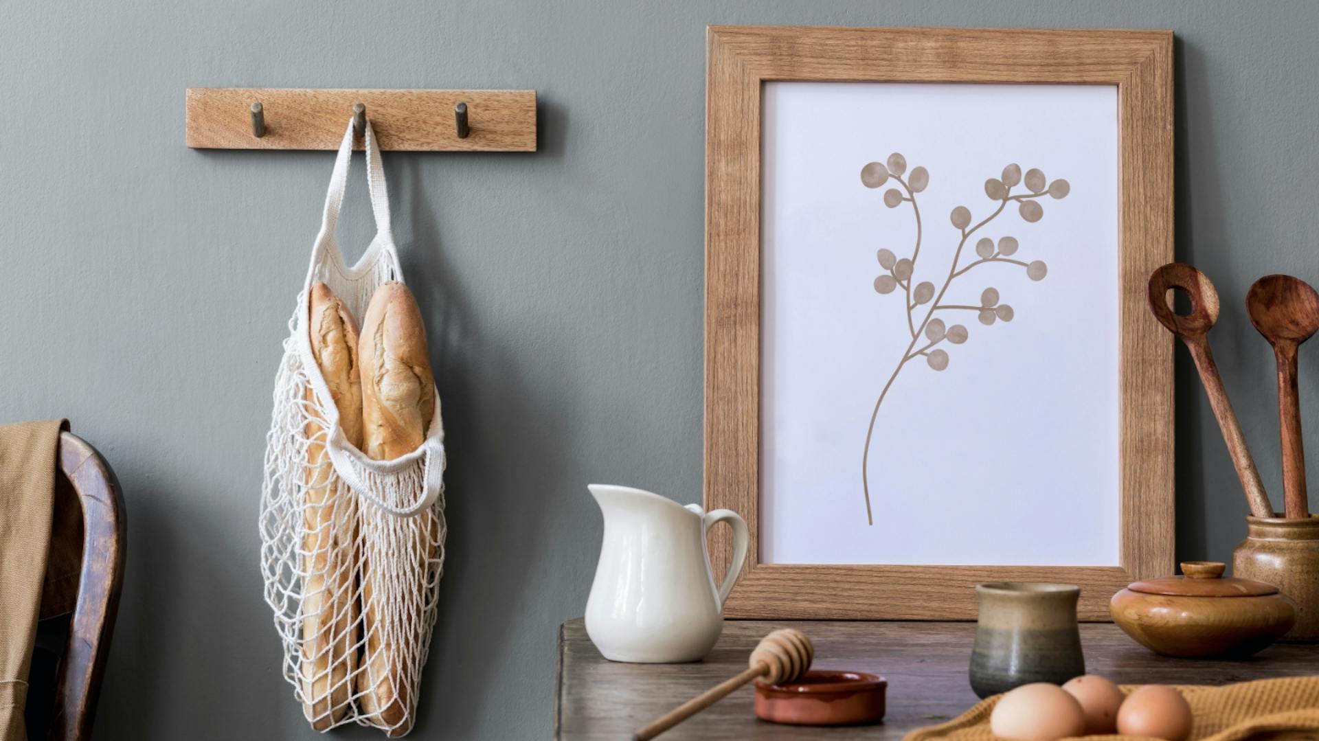 Tartó a konyhában élelmiszerrel, képkeret és bevásárlótáska a szürke falon