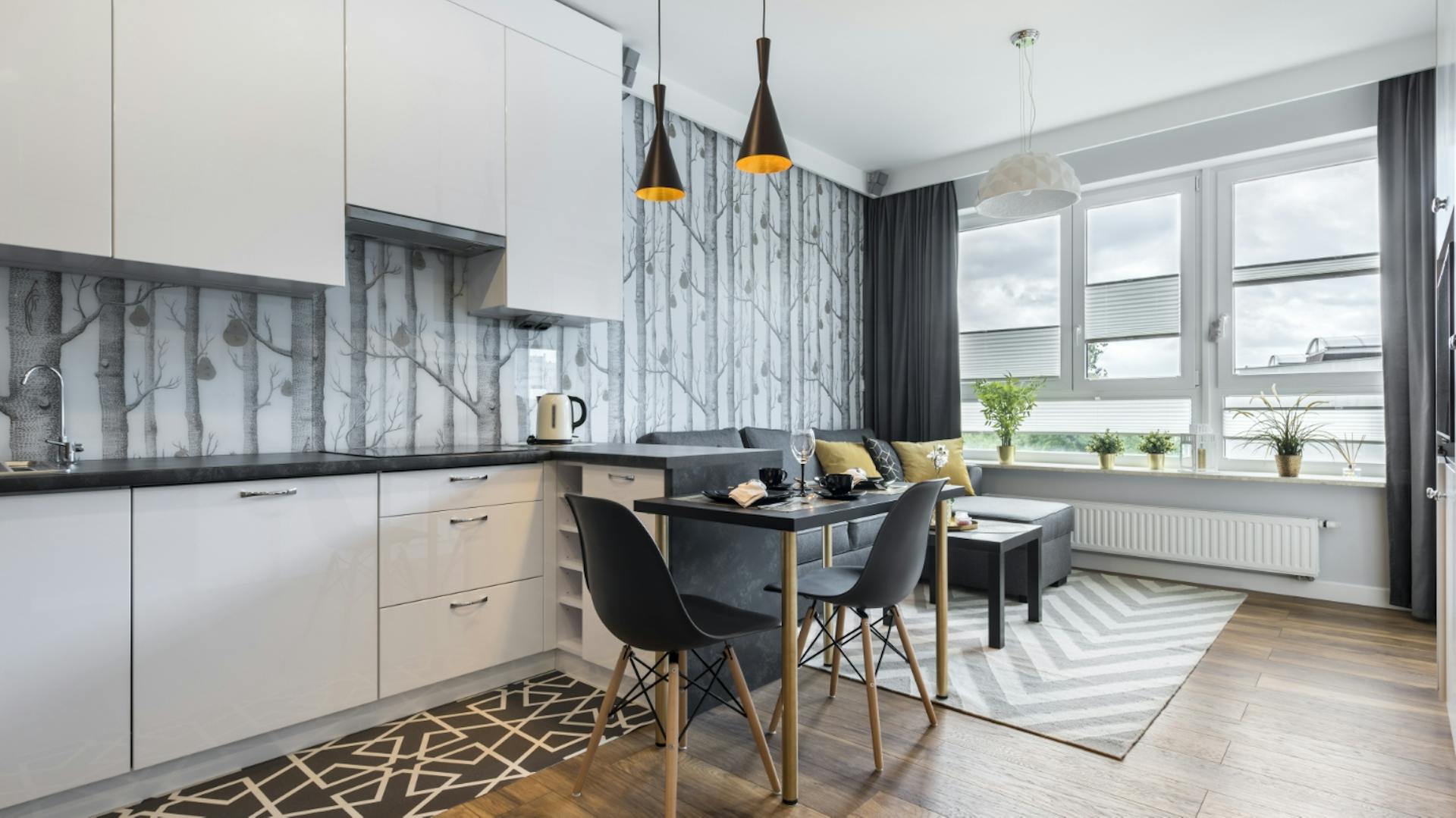 Küche und Wohnzimmer in einem Raum mit grauer Tapete mit Waldmotiv