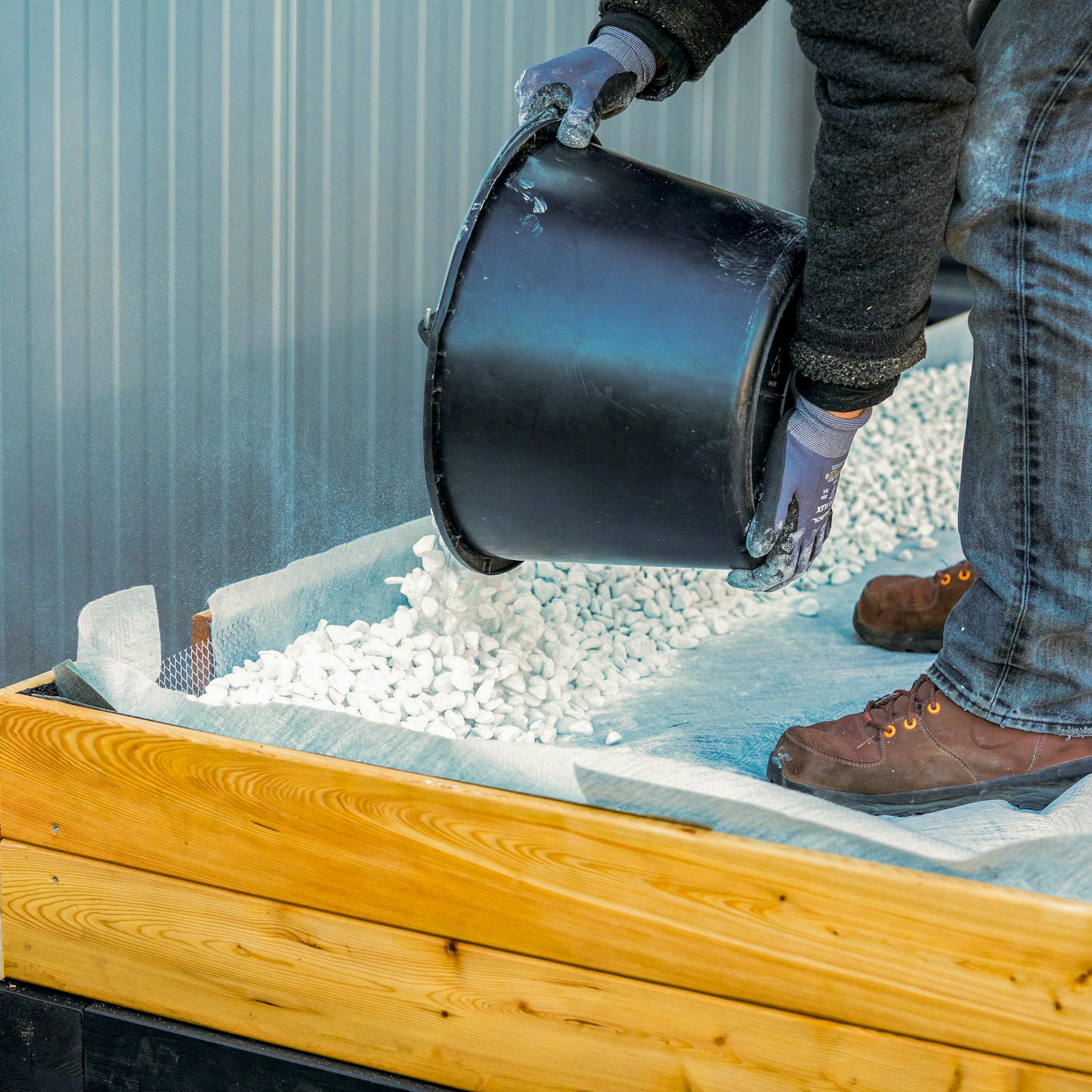 Zierkies wird auf ein Dach geschüttet.