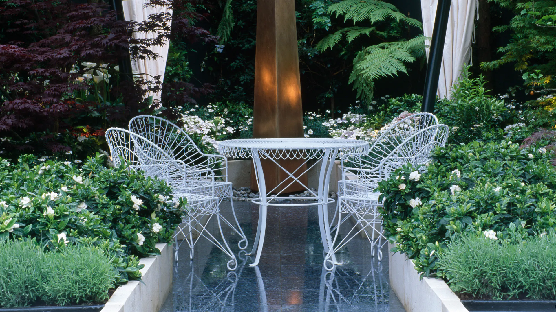 Gartentisch mit Stühlen in Garten mit Gardenien