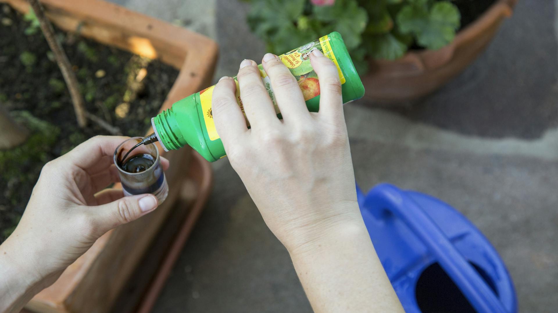 Eine Person füllt Flüssigdünger ab.