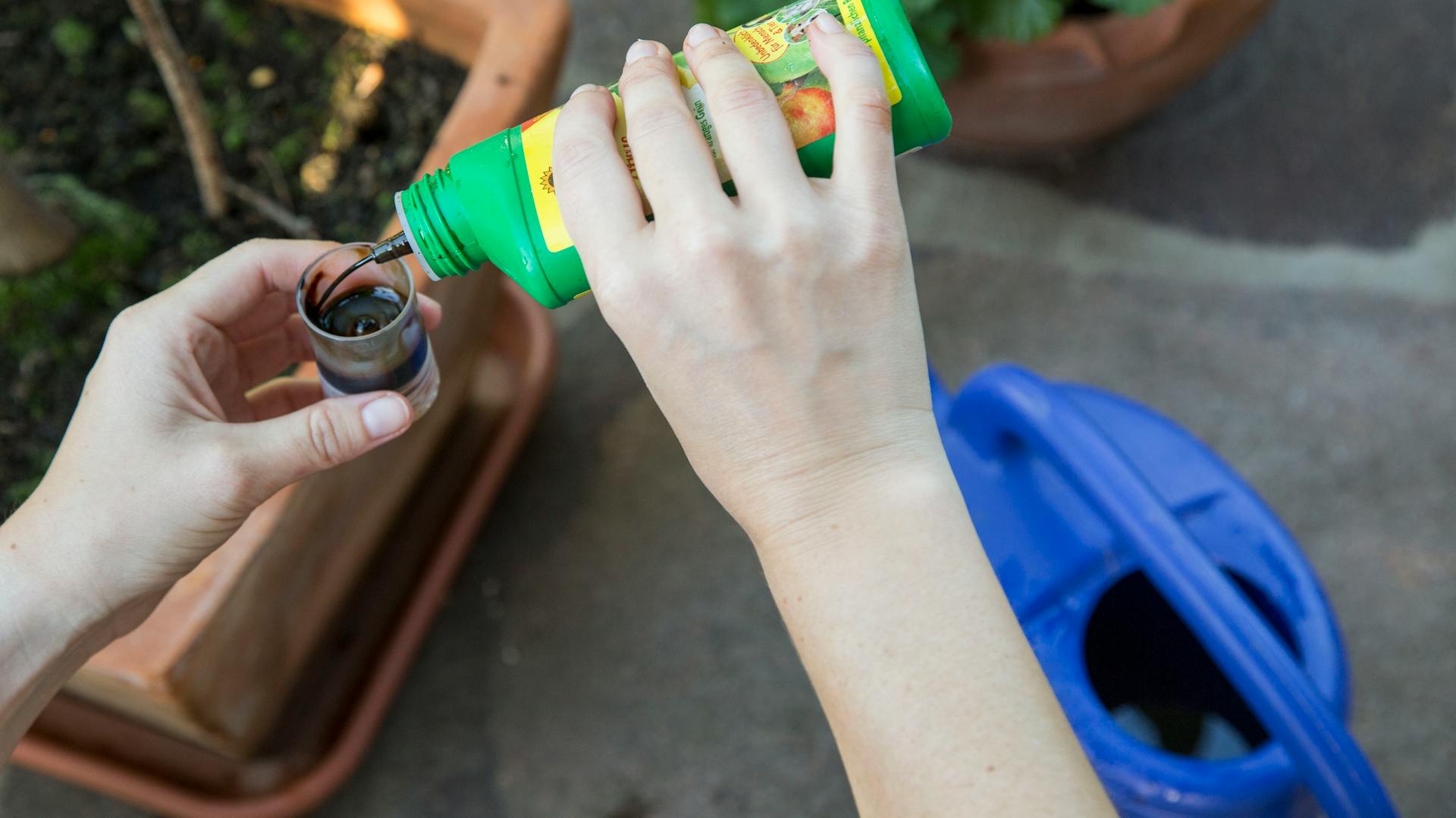 Eine Person füllt Flüssigdünger ab.