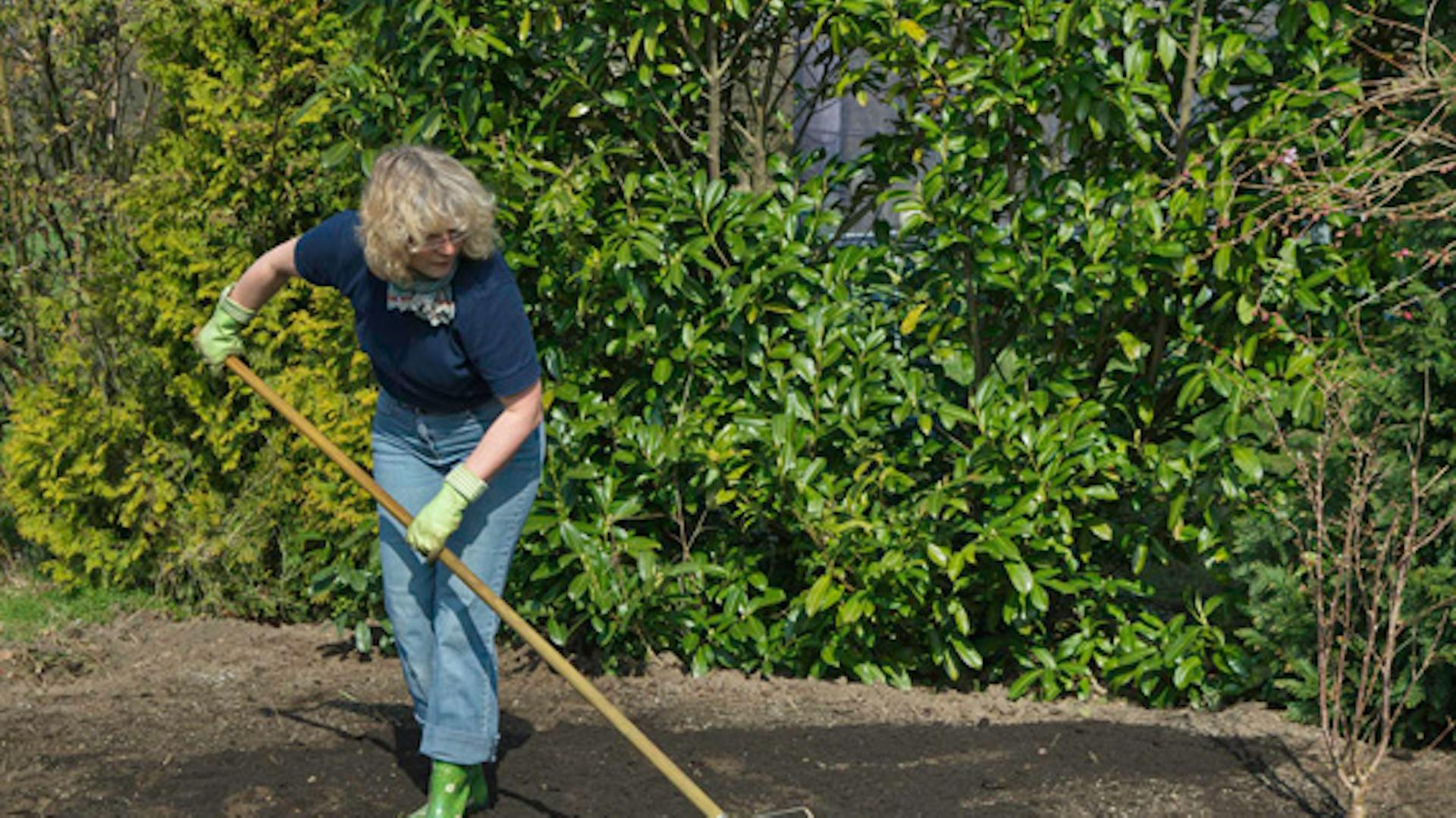 Una donna sparge fertilizzante in giardino