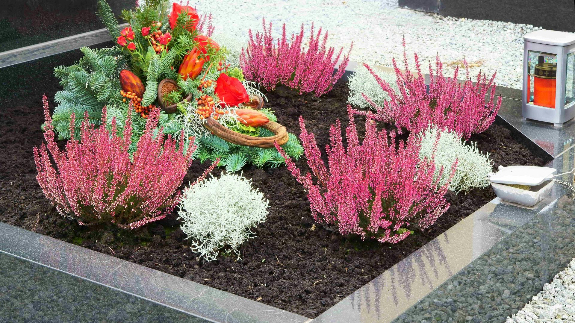 Grab mit Herbstpflanzen und Grabgesteck