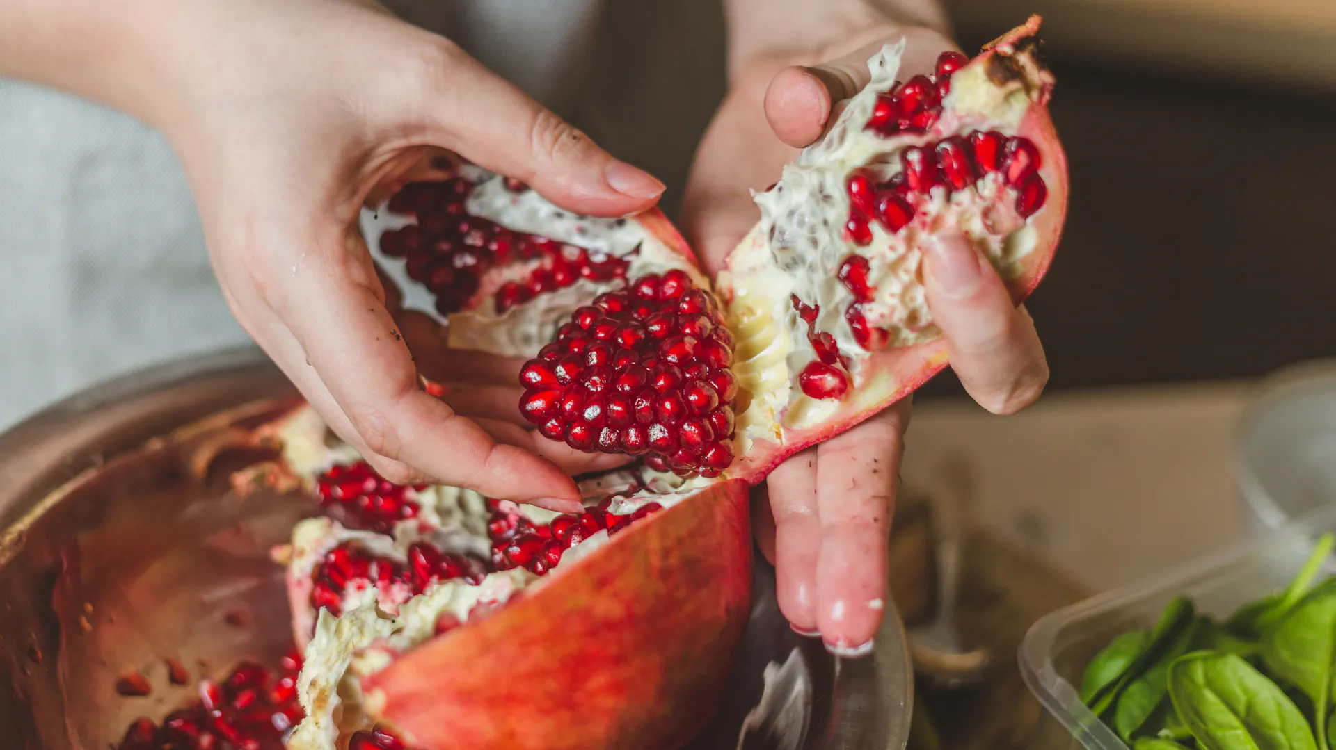 Eine Person öffnet einen Granatapfel
