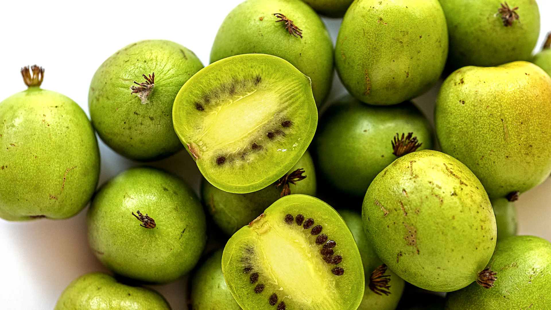 Viele Kiwibeeren liegen beieinander.