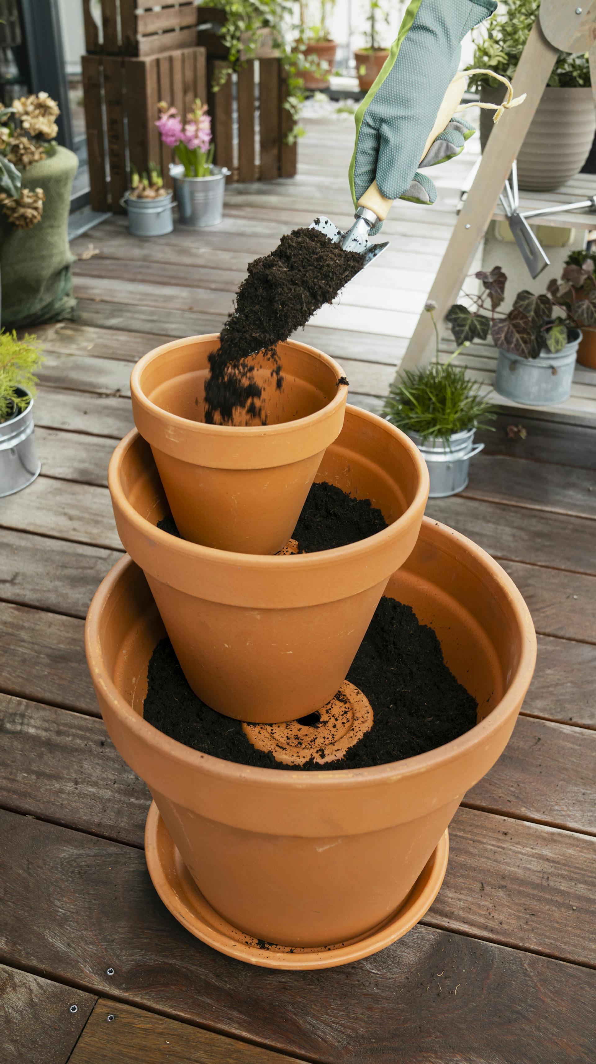 Una torre di vasi viene riempita con terriccio