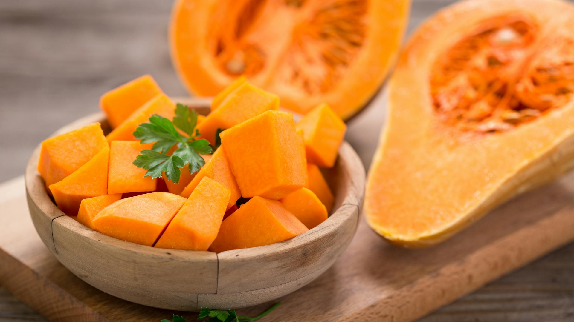 Gewürfelter Kürbis liegt in einer Holzschale.