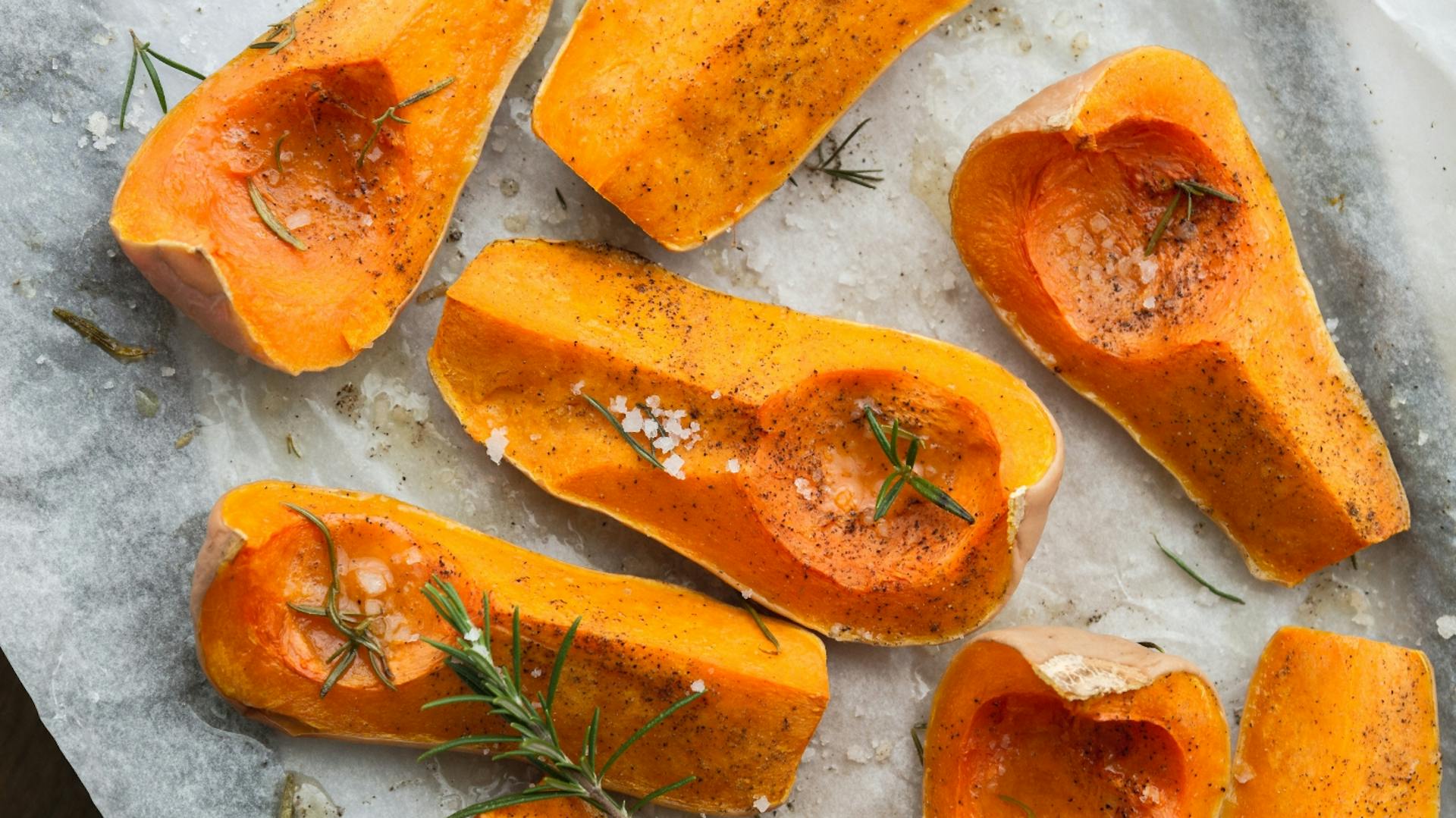 Hände ernten einen Kürbis