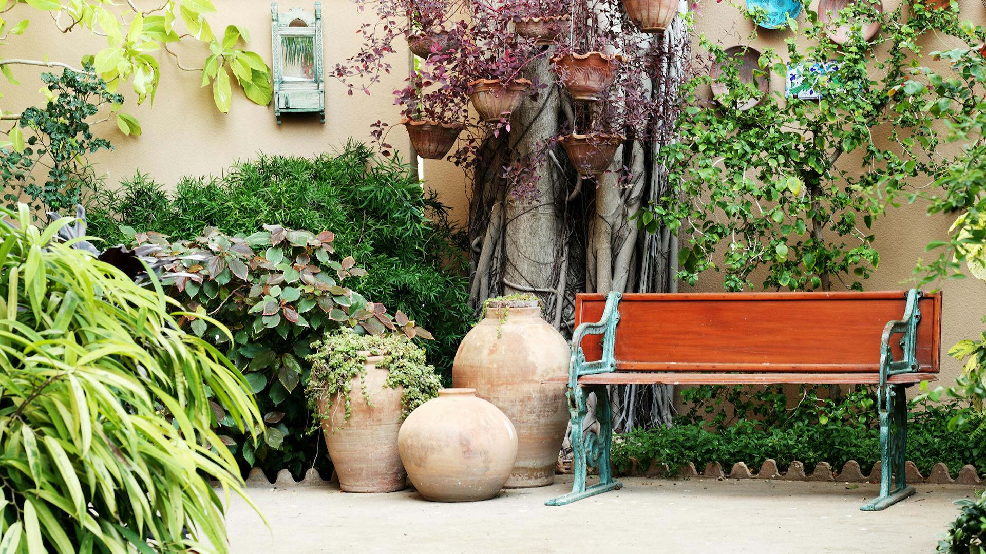 Mediterrane Terrasse mit Bank und Terrakotta Töpfen
