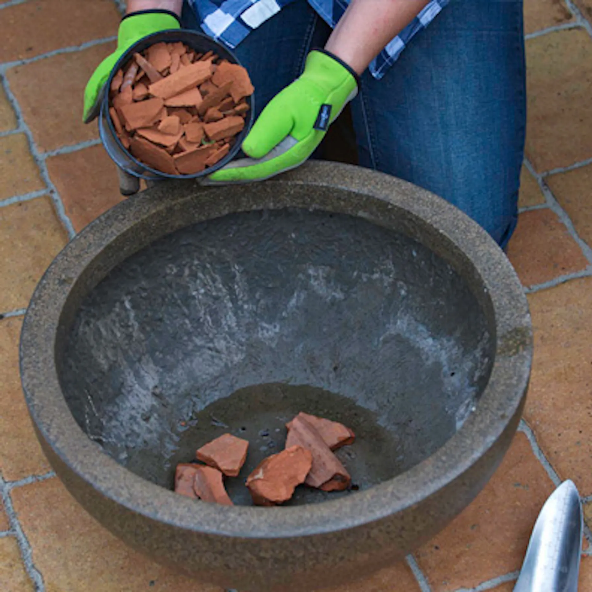 i frammenti di argilla vengono posizionati come strato di drenaggio in una fioriera.