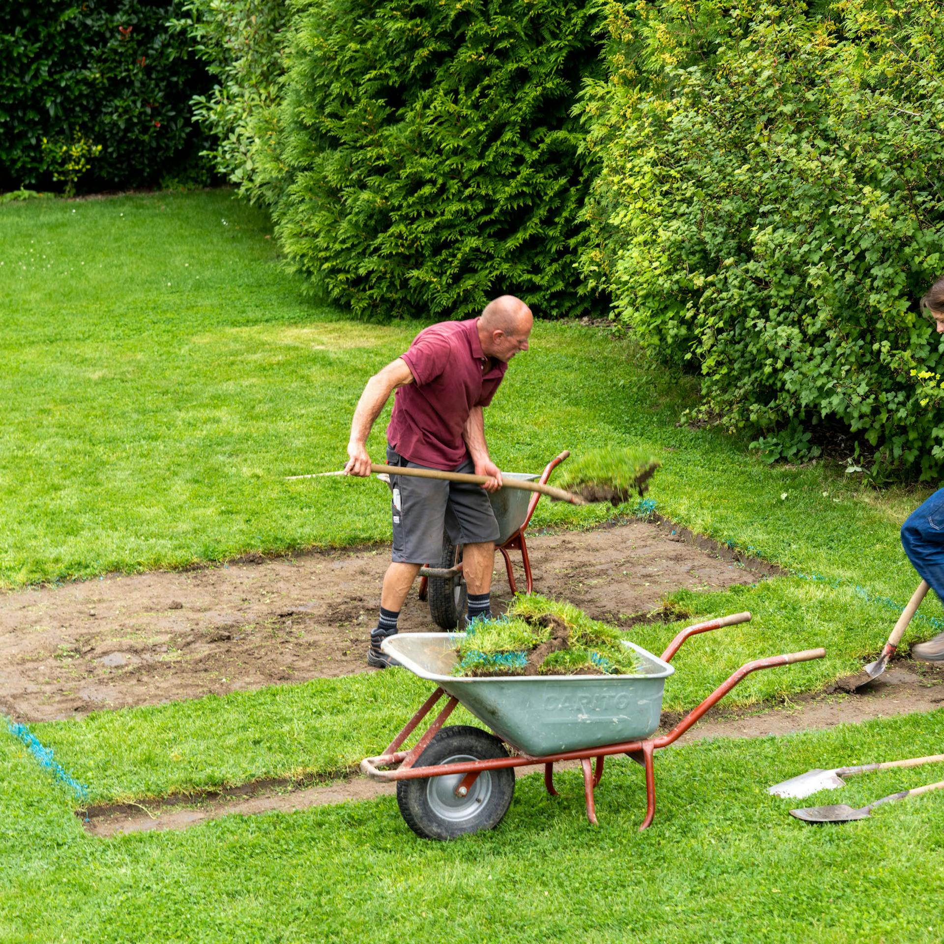 Dvě osoby odstraňují travní porost na vymezené ploše.