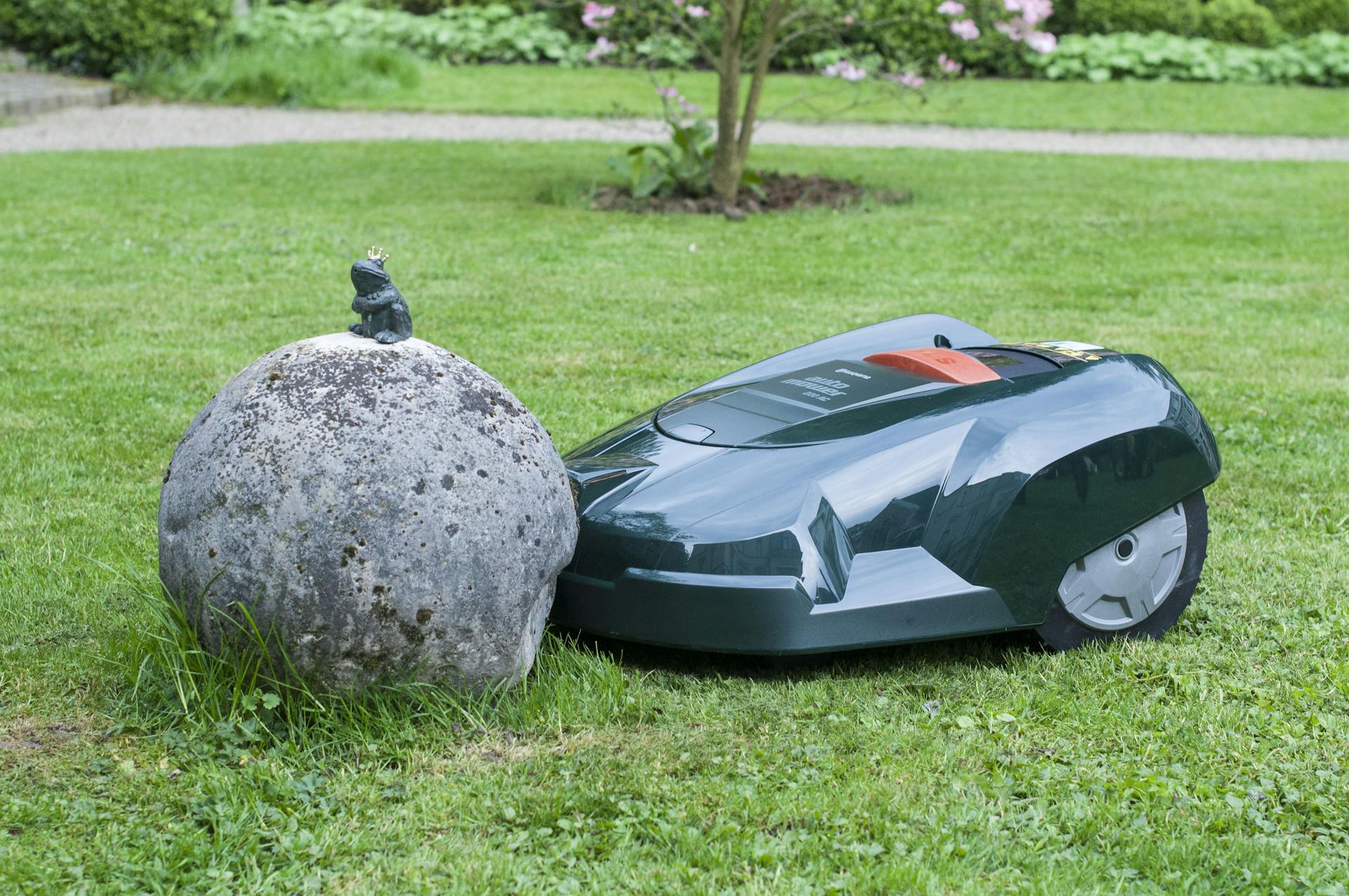 Il robot tosaerba su una superficie erbosa incontra una pietra come ostacolo