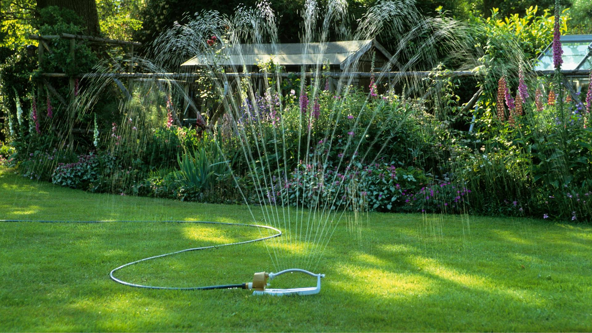 Egy négyszögesőztető öntözi a gyepet.